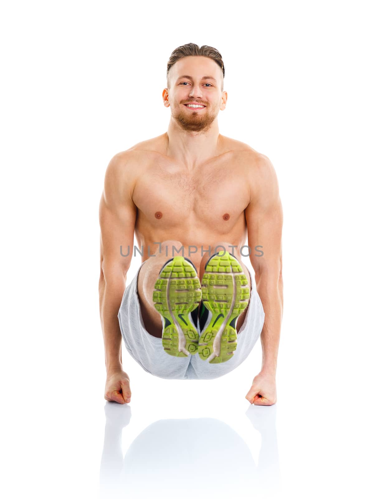 Athletic attractive man doing fitness exercises on the white background