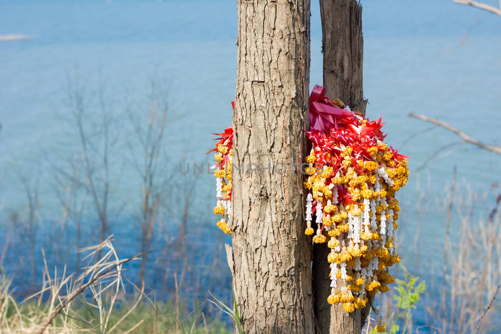 garlands on a trre near dam as background