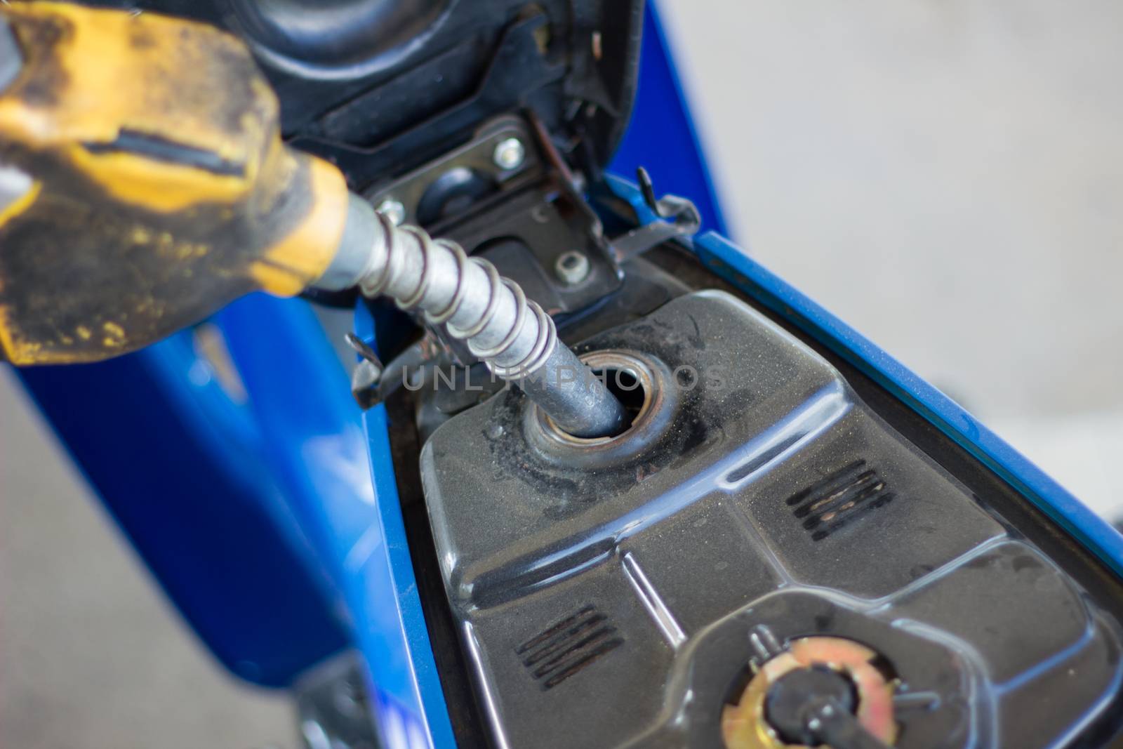 Refueling a motorcycle at a gas station in thailand