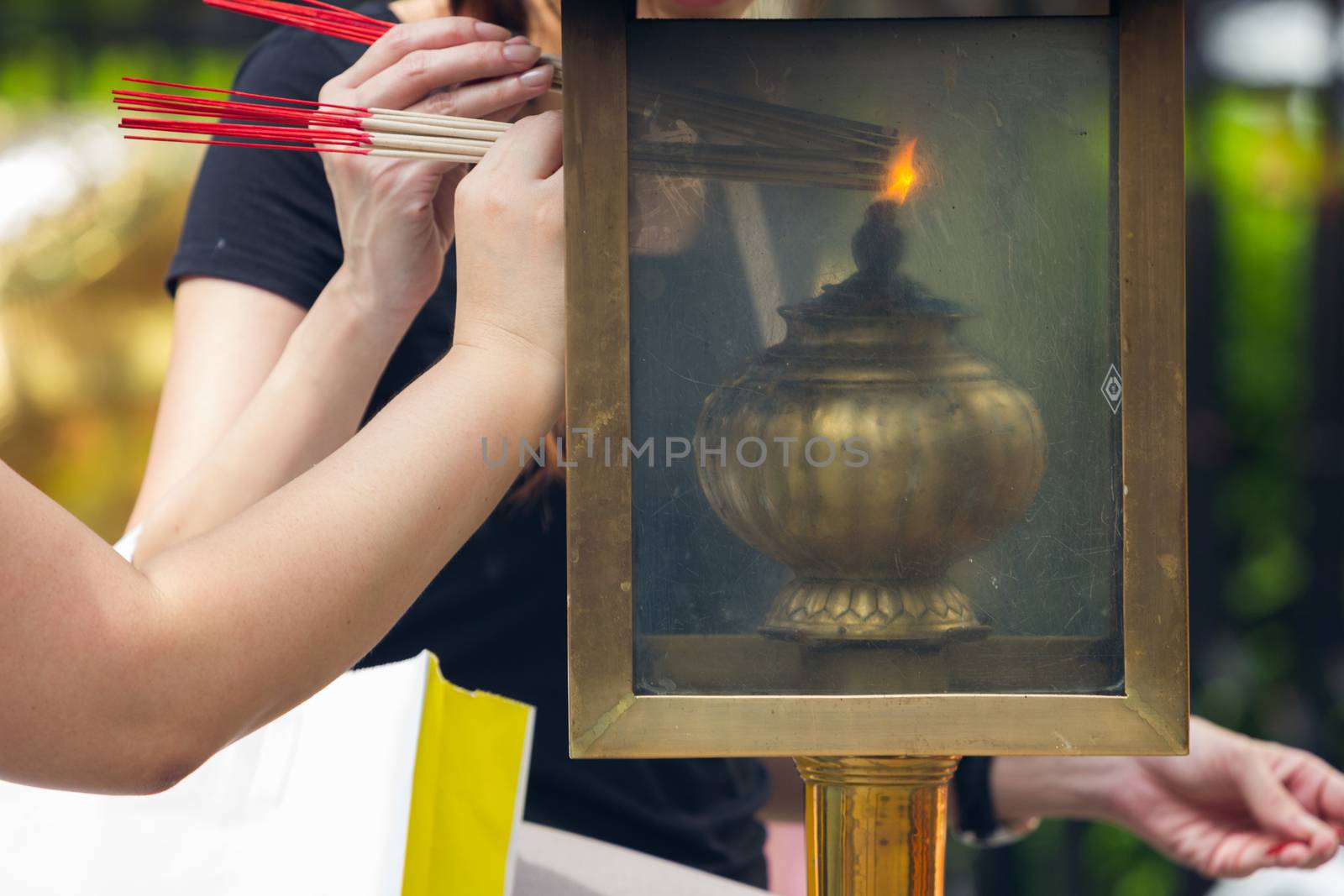 people lighting Incense sticks with lamp in Thailand