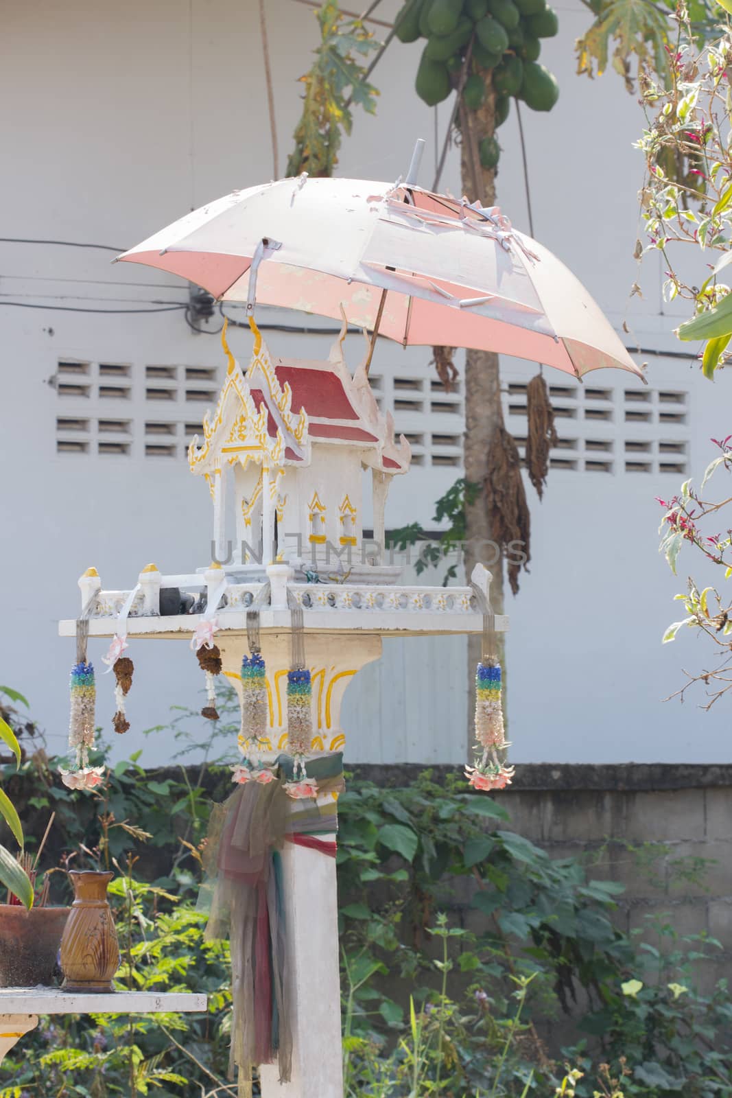 white spirit house in thailand with old umbrella  by a3701027