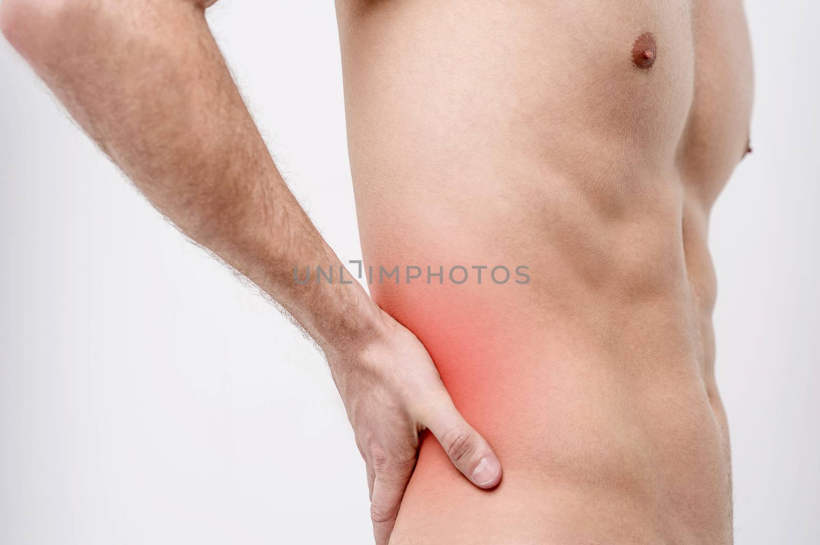 Shirtless male holding his back for the pain