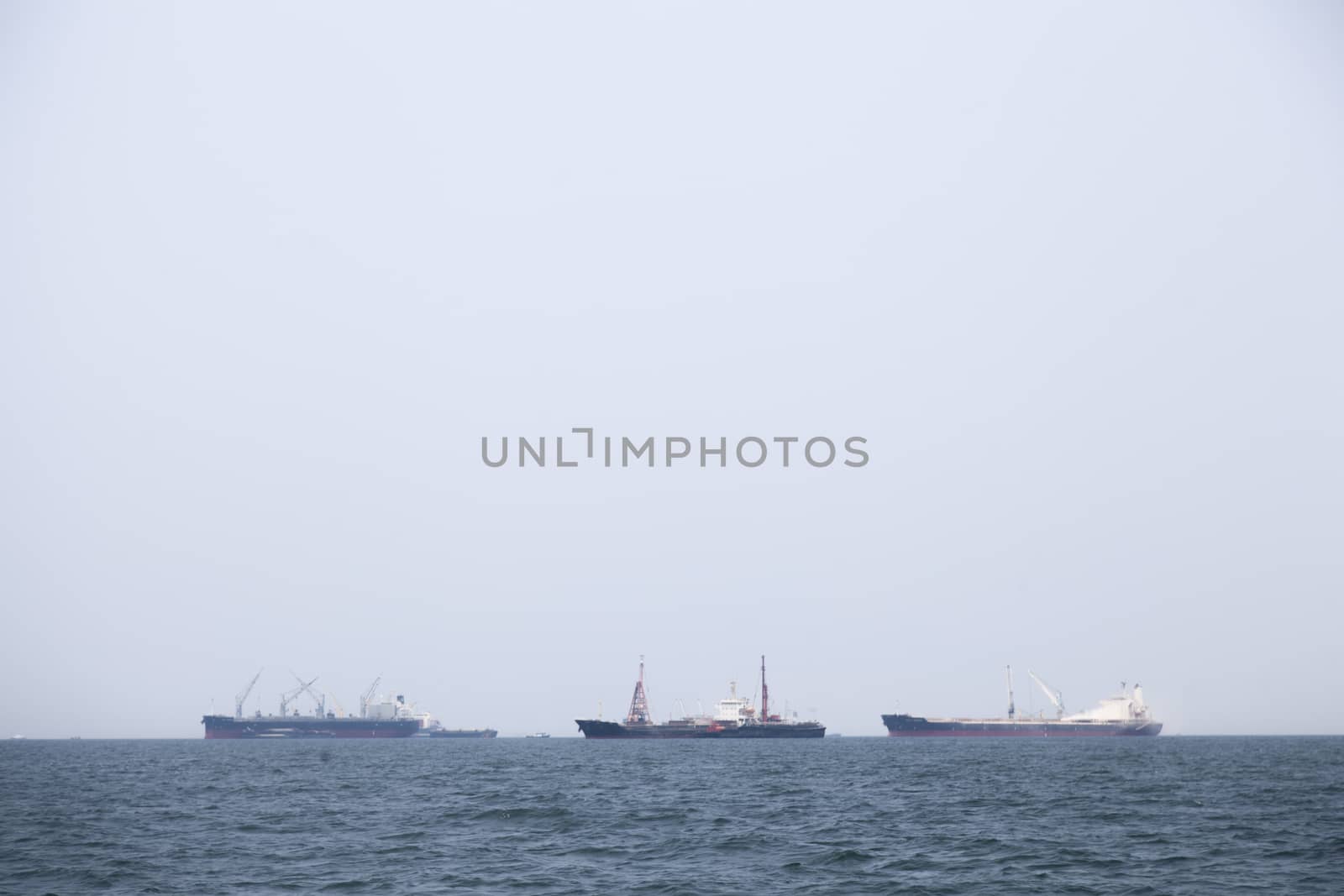 Large cargo ship Boats moored in the sea to make sense compared to the coast.