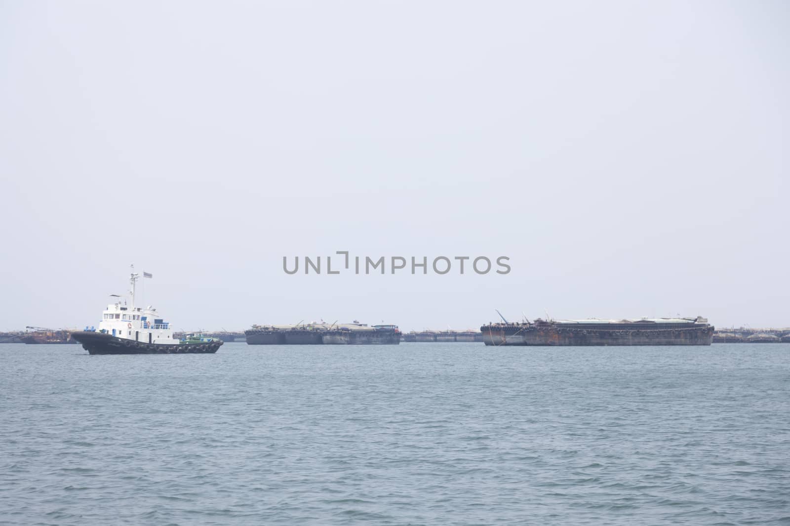 Large cargo ship Boats moored in the sea to make sense compared to the coast.