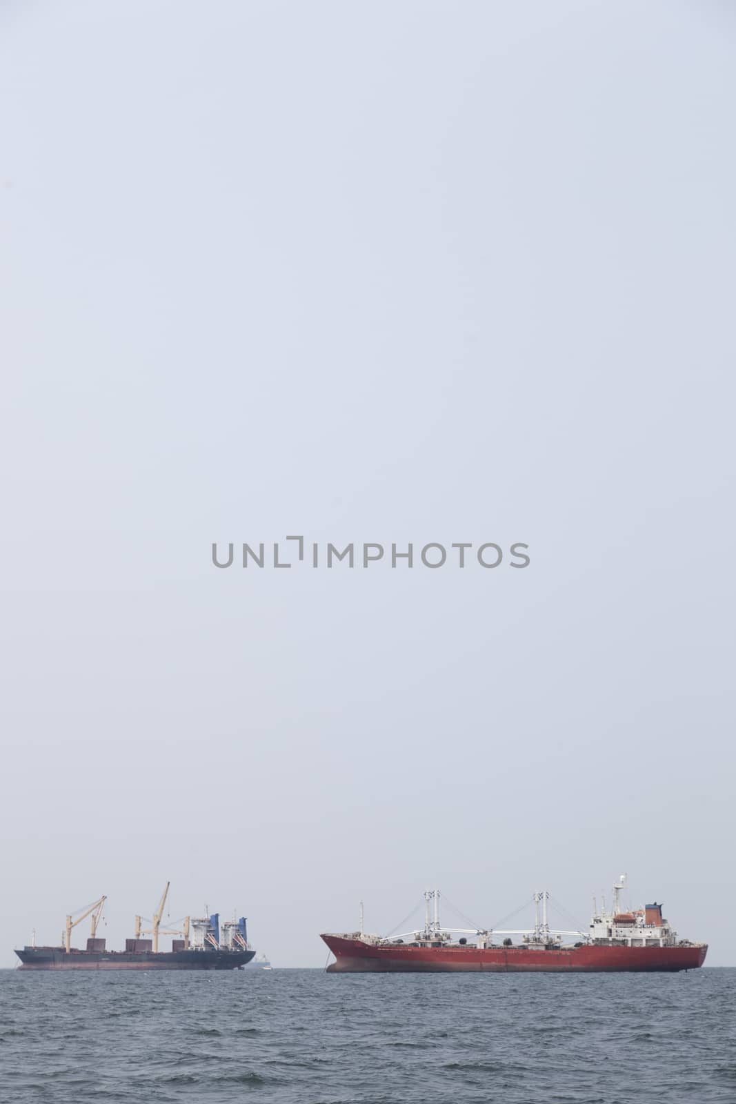 Large cargo ship Boats moored in the sea to make sense compared to the coast.