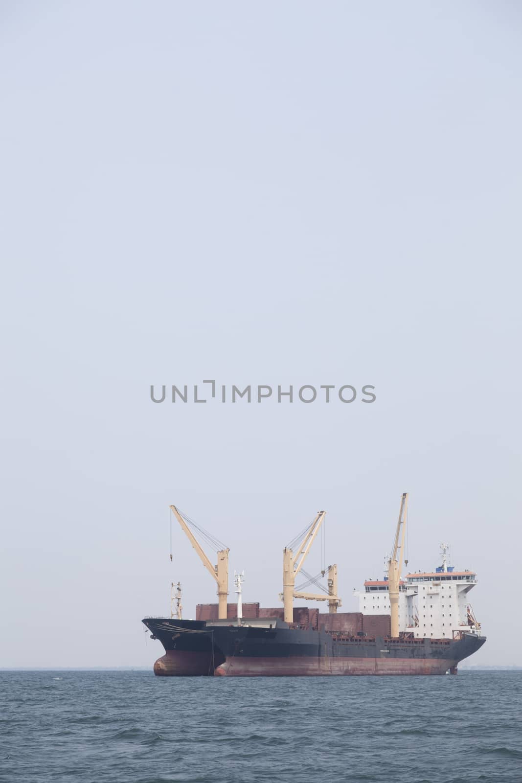 Large cargo ship Boats moored in the sea to make sense compared to the coast.