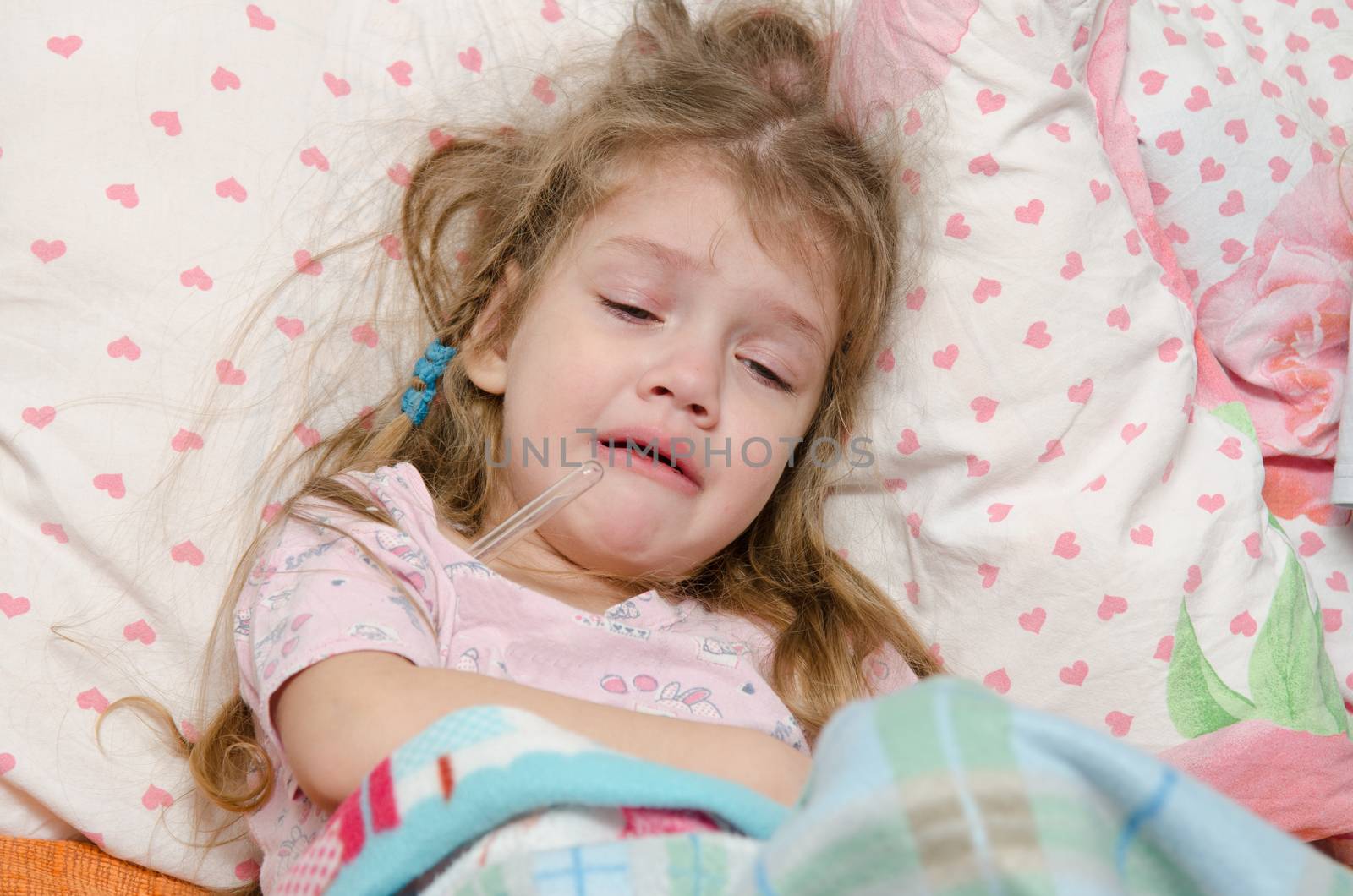 The three-year diseased girl lying in bed, Meria temperature thermometer, in a bad mood