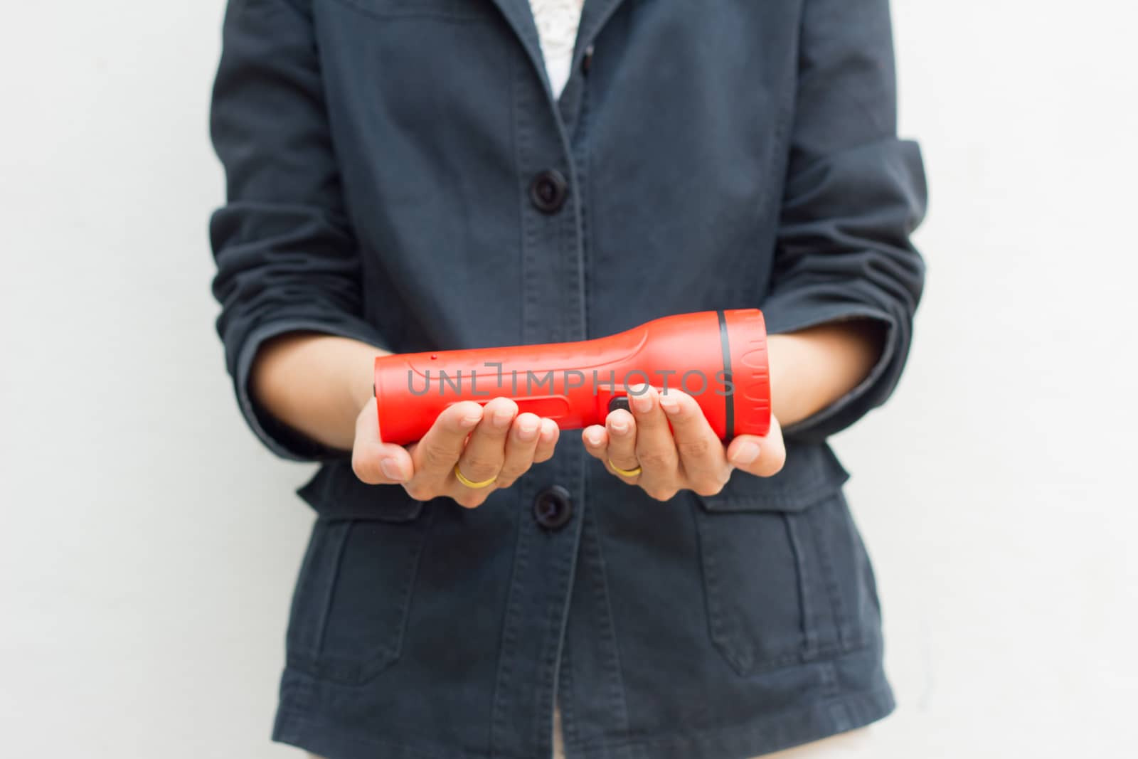 Hands of woman holding red flashlight