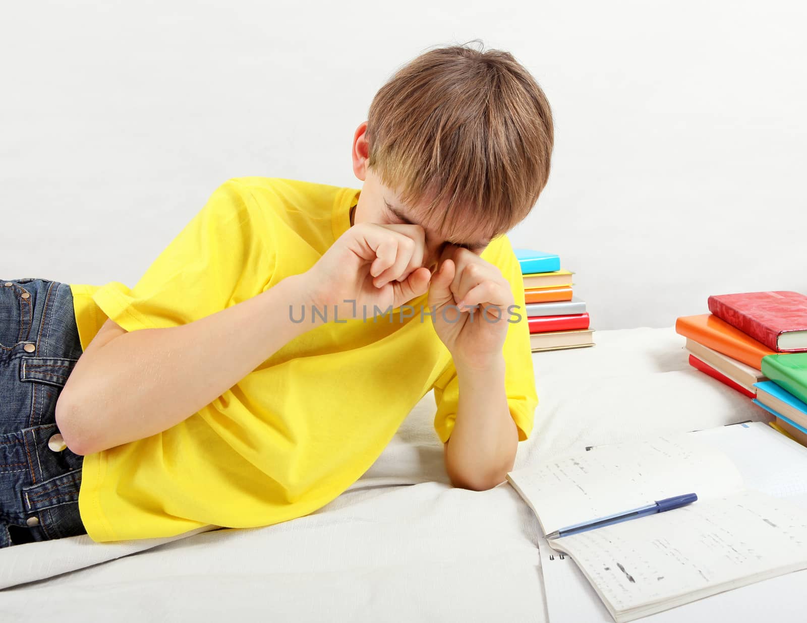 Tired Teenager doing Homework by sabphoto