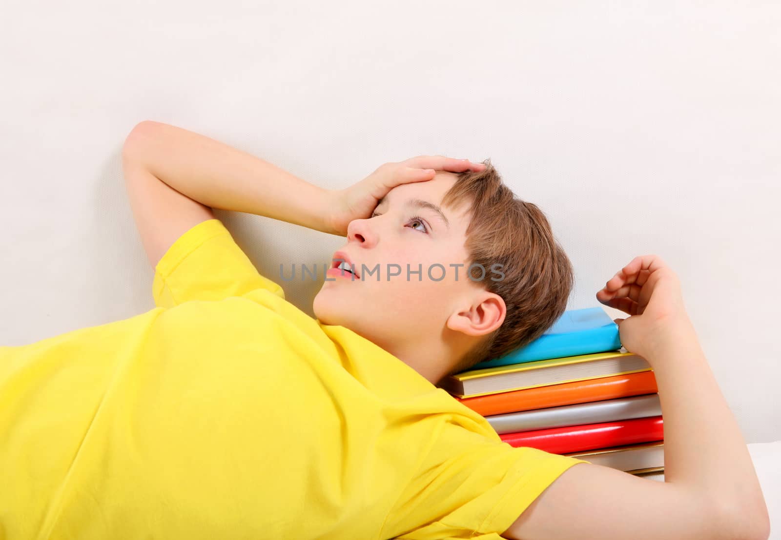 Tired Teenager with a Books at the Home