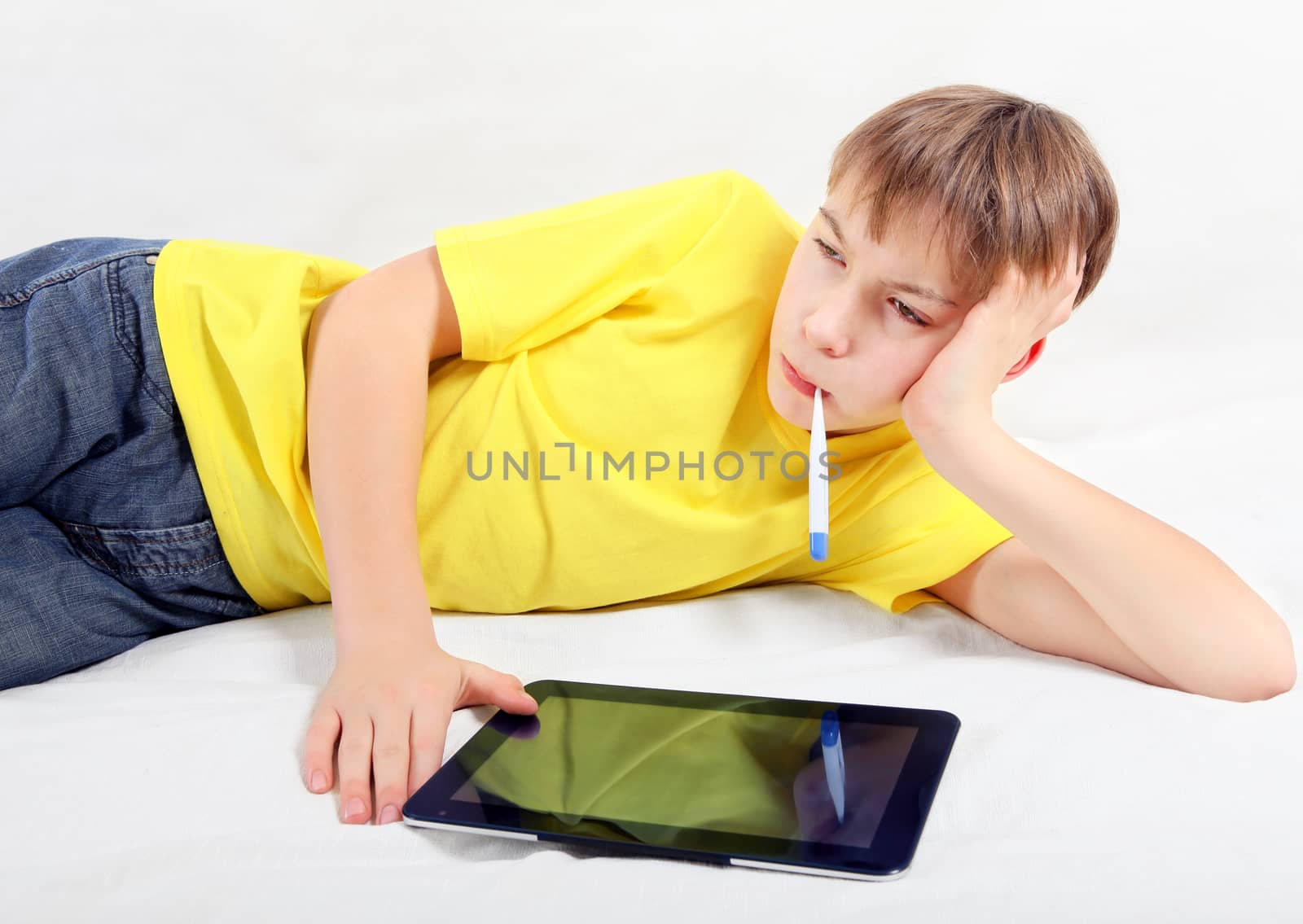 Sick Teenager with Tablet Computer by sabphoto