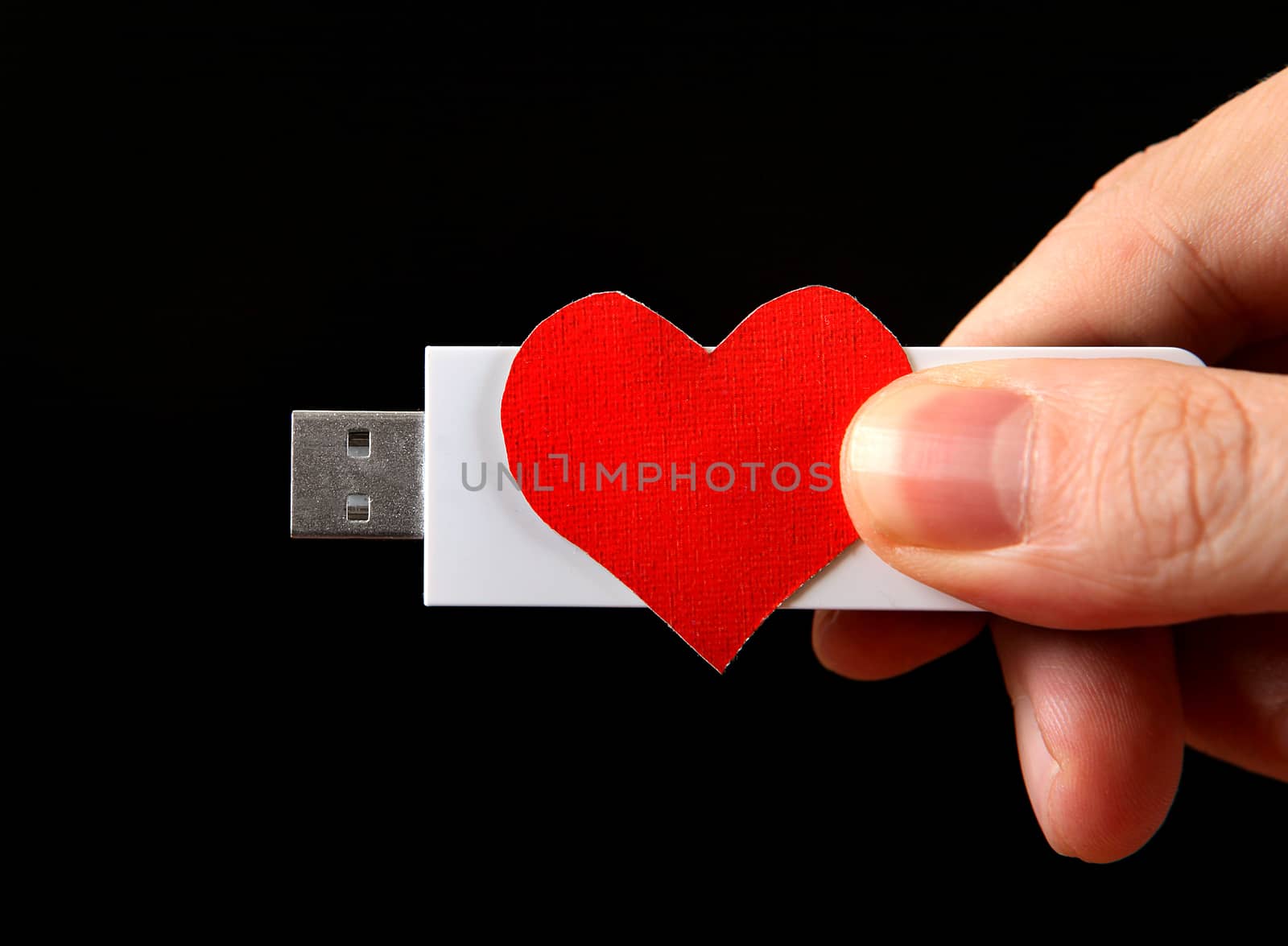 Heart Shape and USB Drive in the Hand on the Black Background