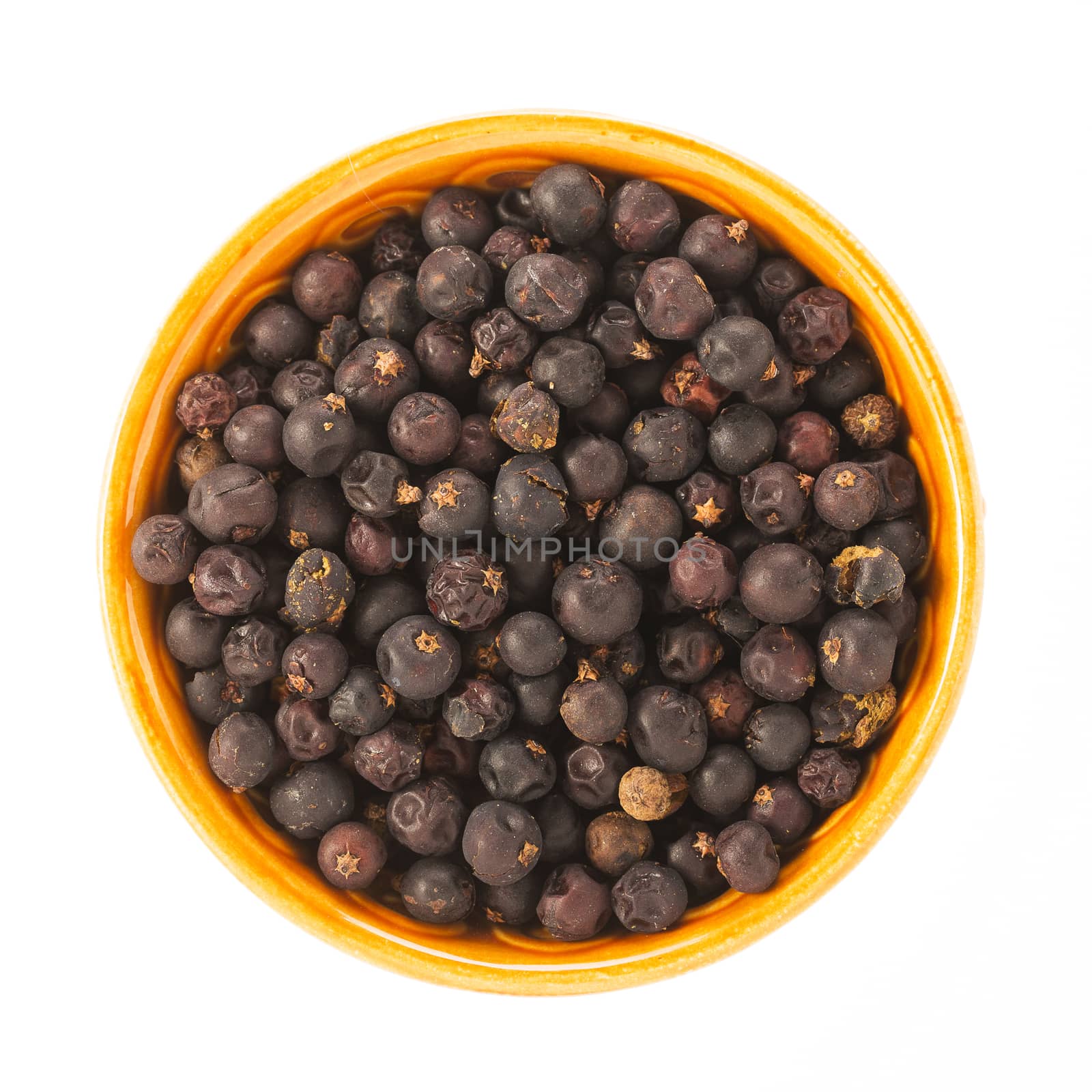 Juniper berries in bowl isolated on white background.