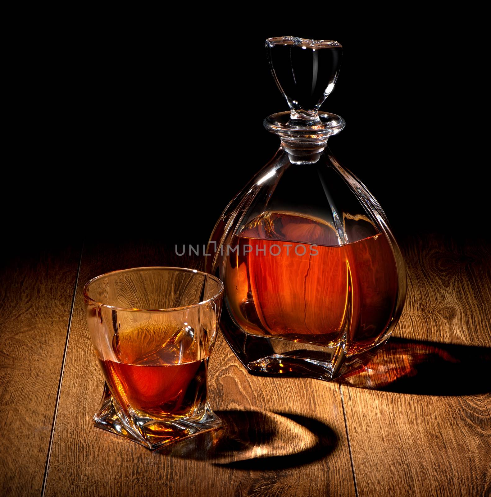 Whiskey on a wooden table on black background