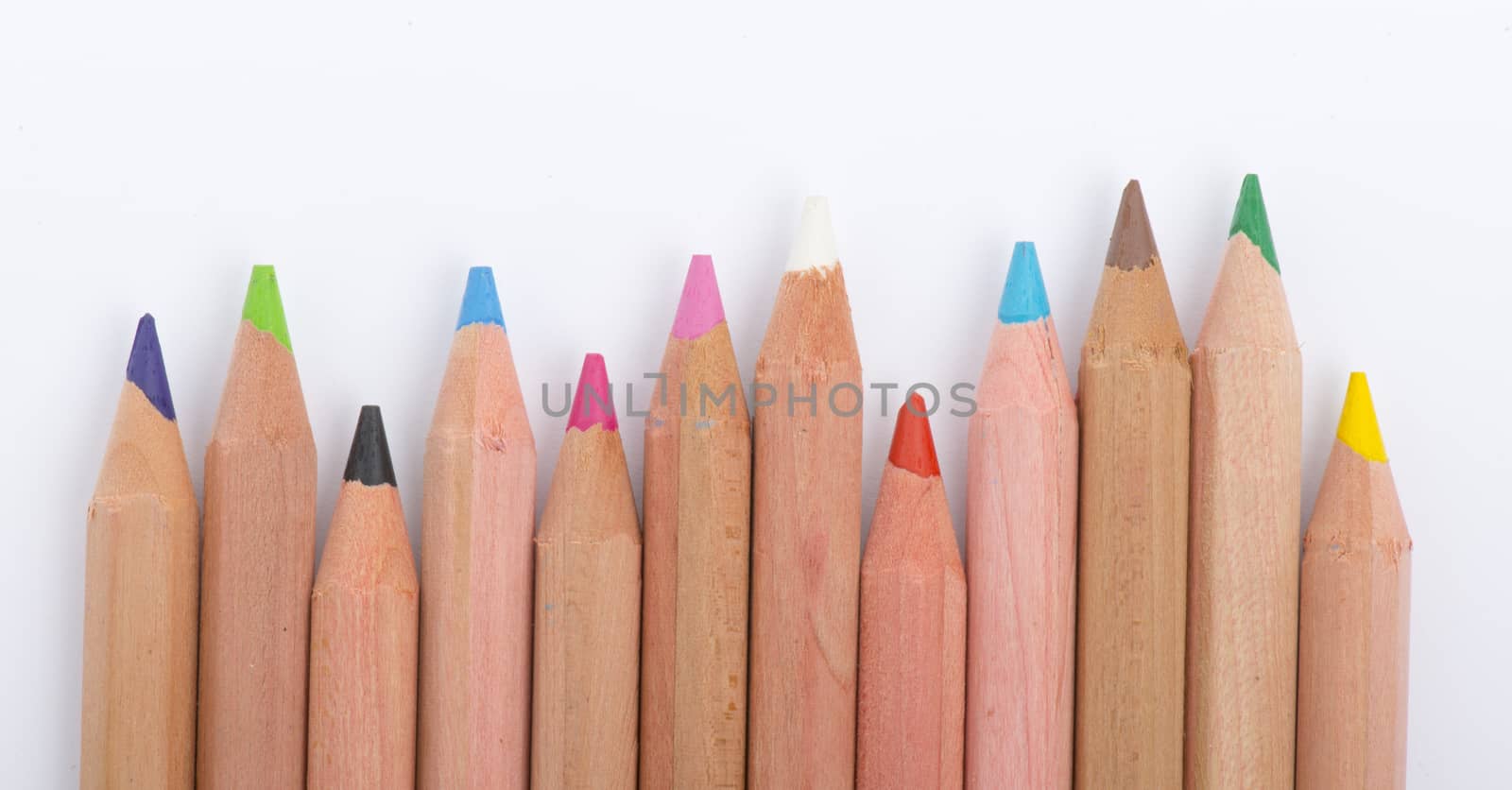 Colour pencils on white background close up by marius_dragne