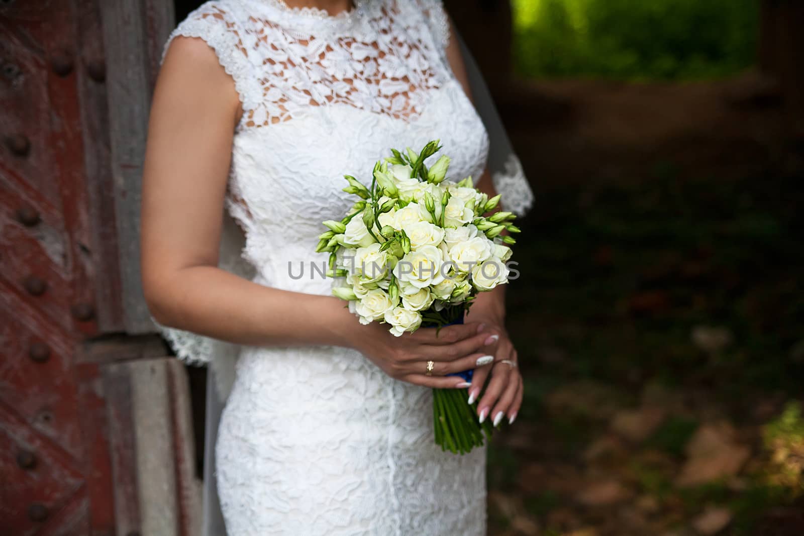 Bride holding wedding flower bouquet of roses. by sfinks