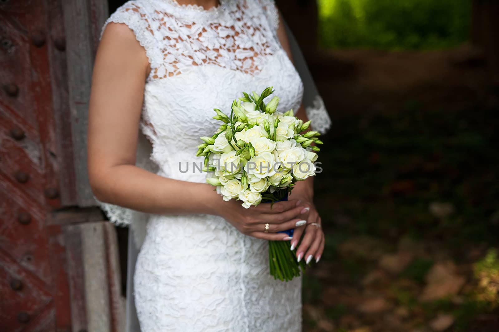 Bride holding wedding flower bouquet of white roses