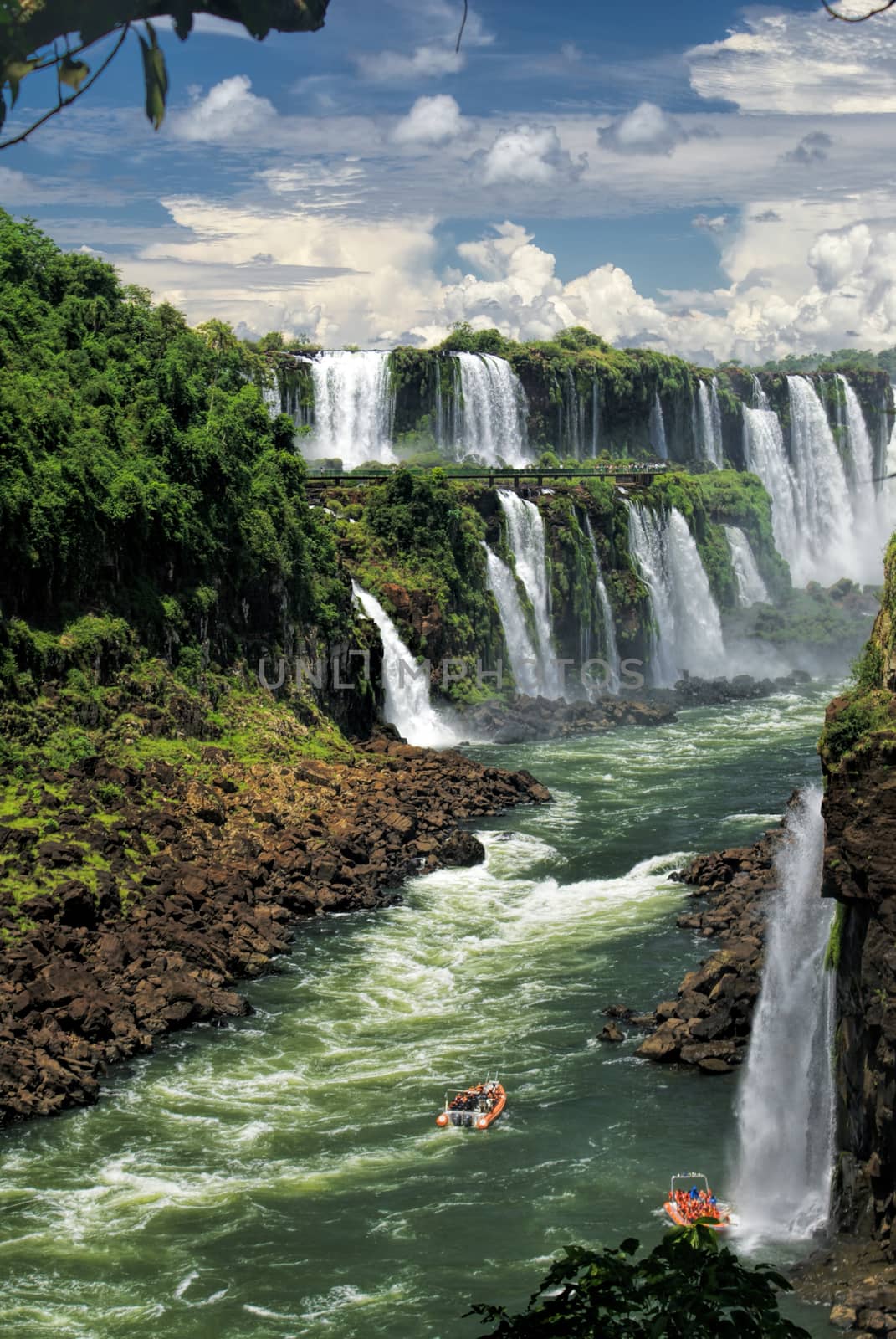 Dramatic view of Iguazu waterfalls in Argentina with tourist boats on the river         