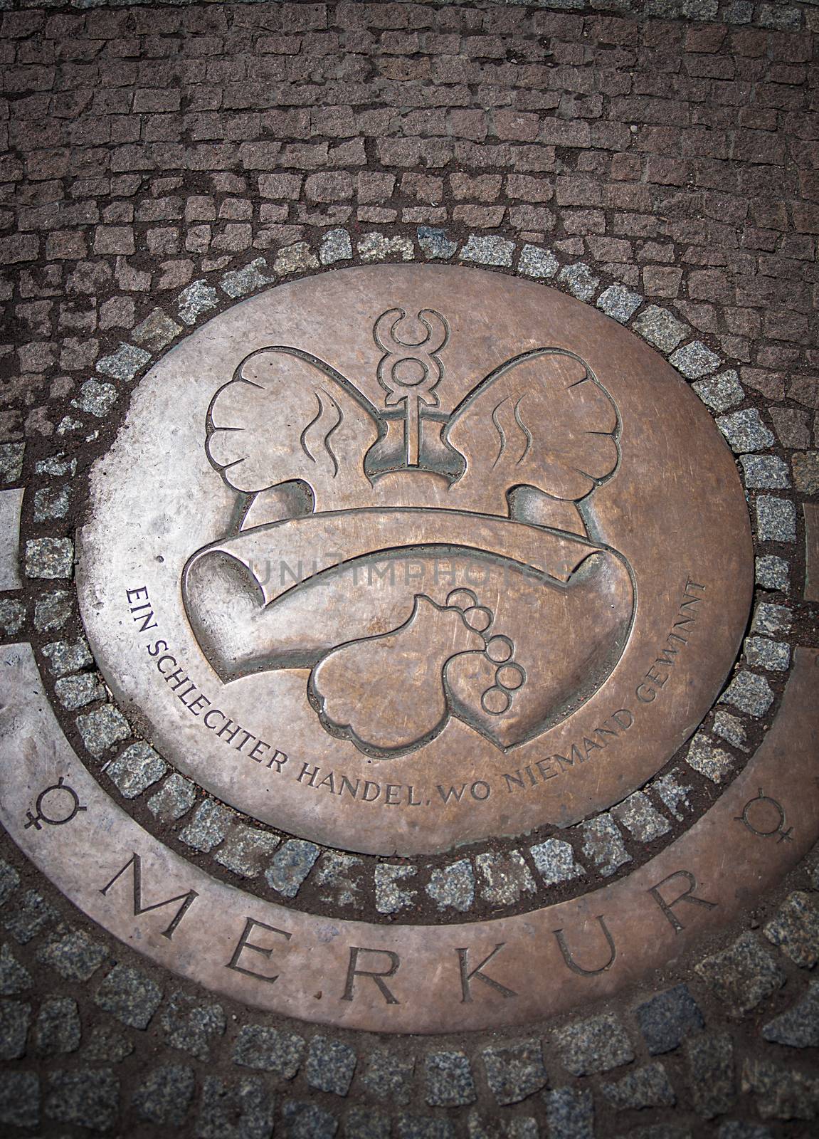 Round Iron hatch for sewer on cobblestone pavement in Dresden, Germany. Steel sewer manhole on pavement.