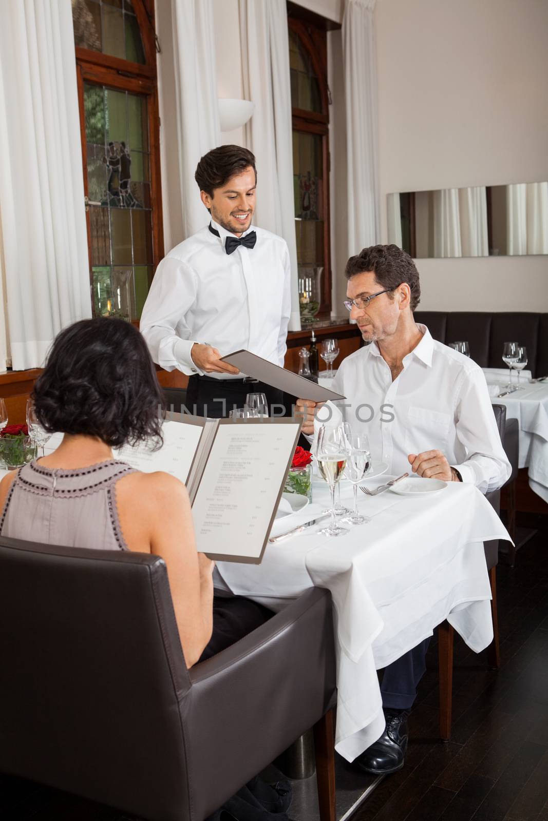 young smiling couple at the restaurant  by juniart