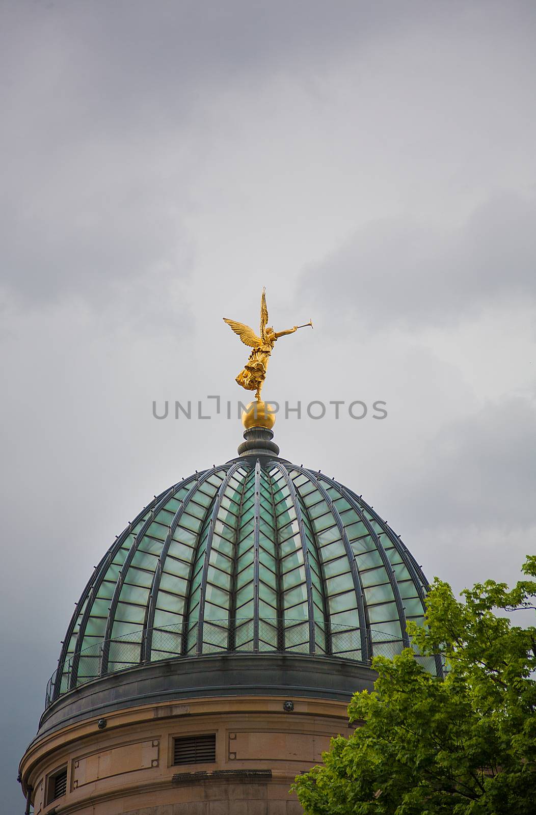 Golden angel statue with trumpet on the top of historic house Academy of Fine Arts in Dresden