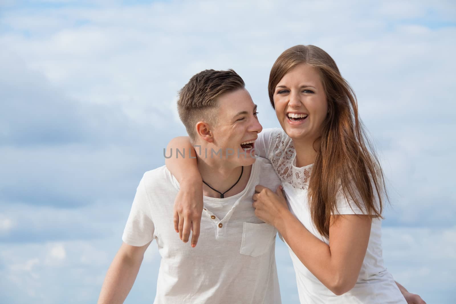 smiling young couple having fun in summer on the beach