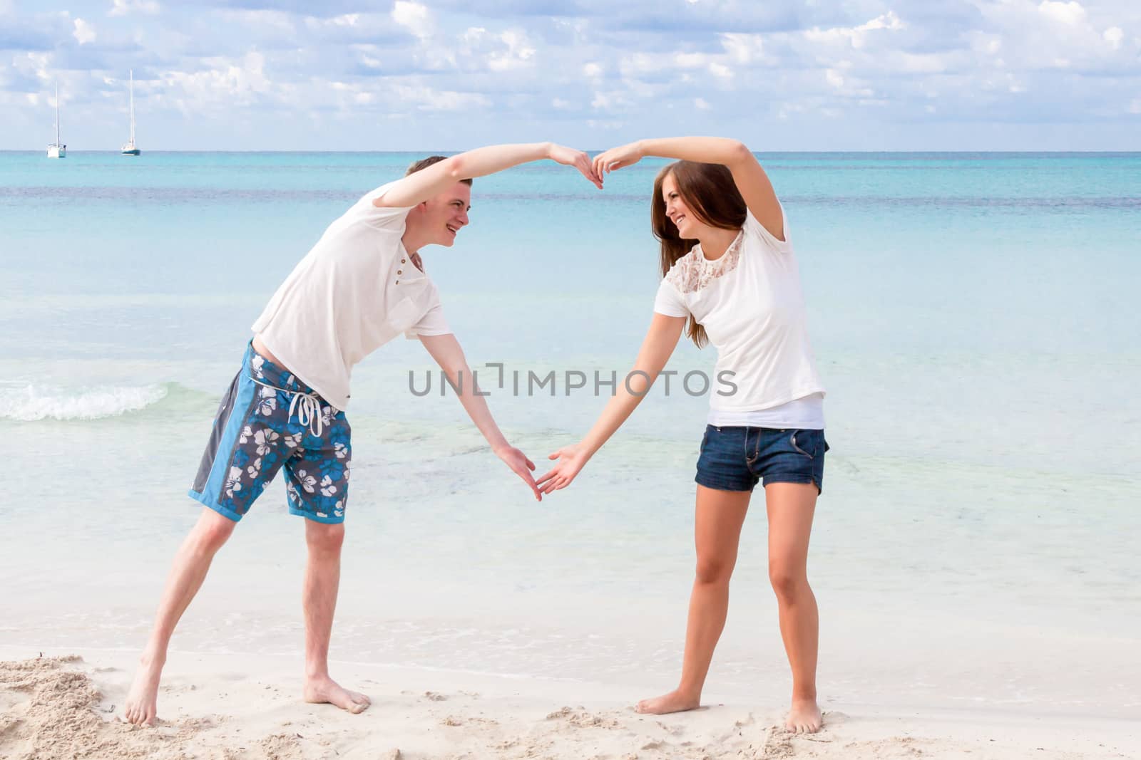 smiling young couple having fun in summer on the beach