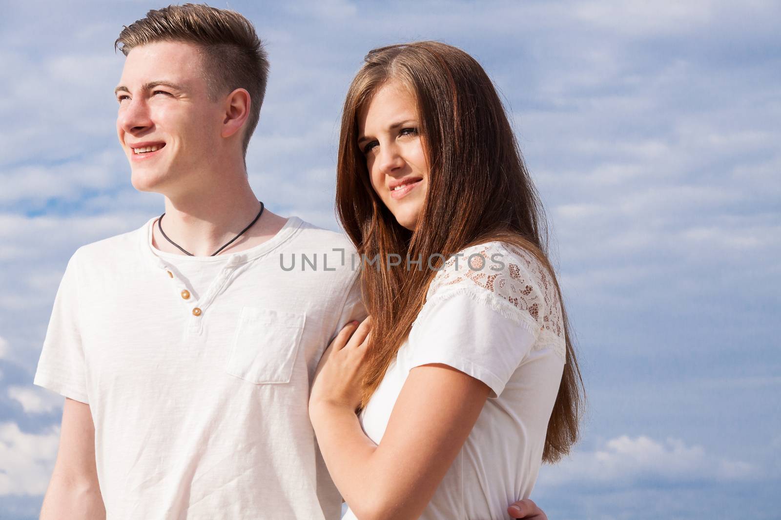 romantic young couple sitting on the beach in summer holiday vacation love