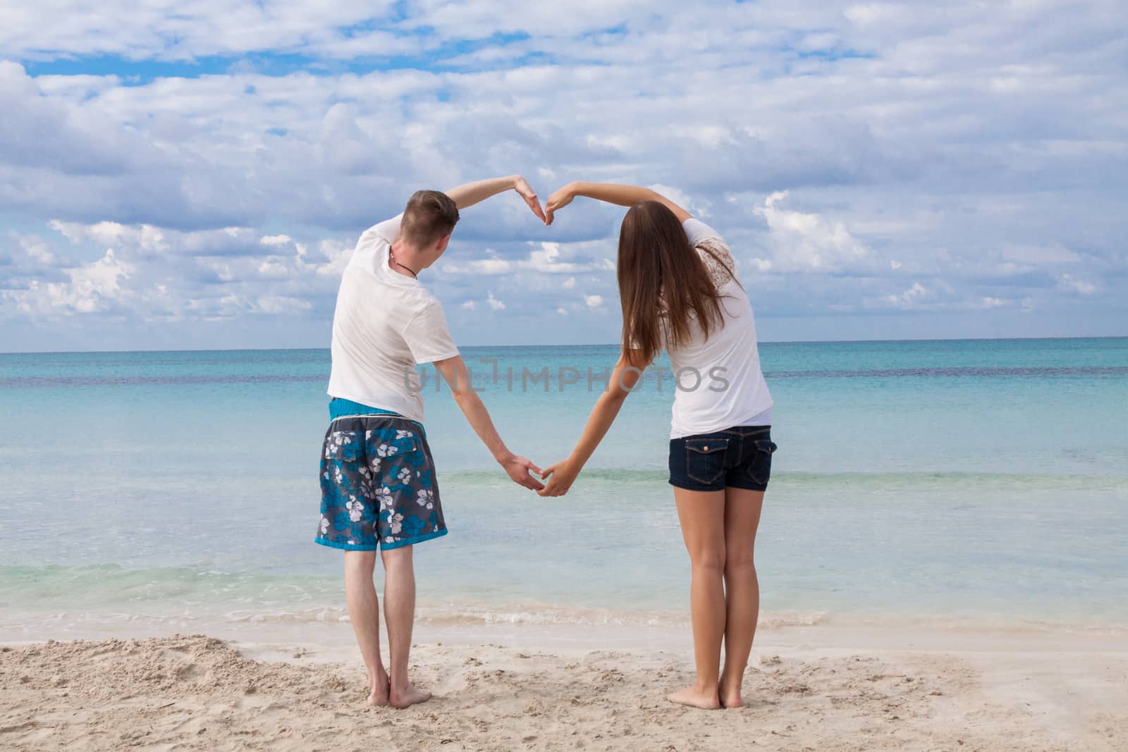 smiling young couple having fun in summer on the beach