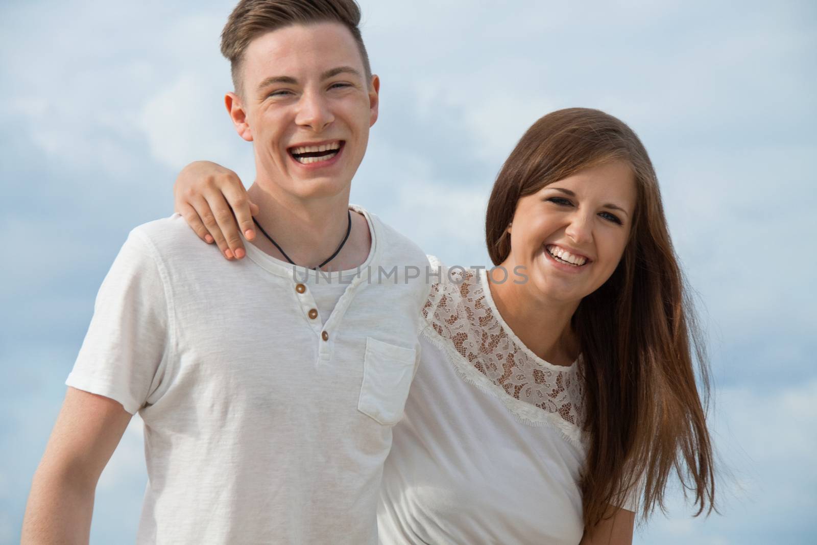 smiling young couple having fun in summer on the beach