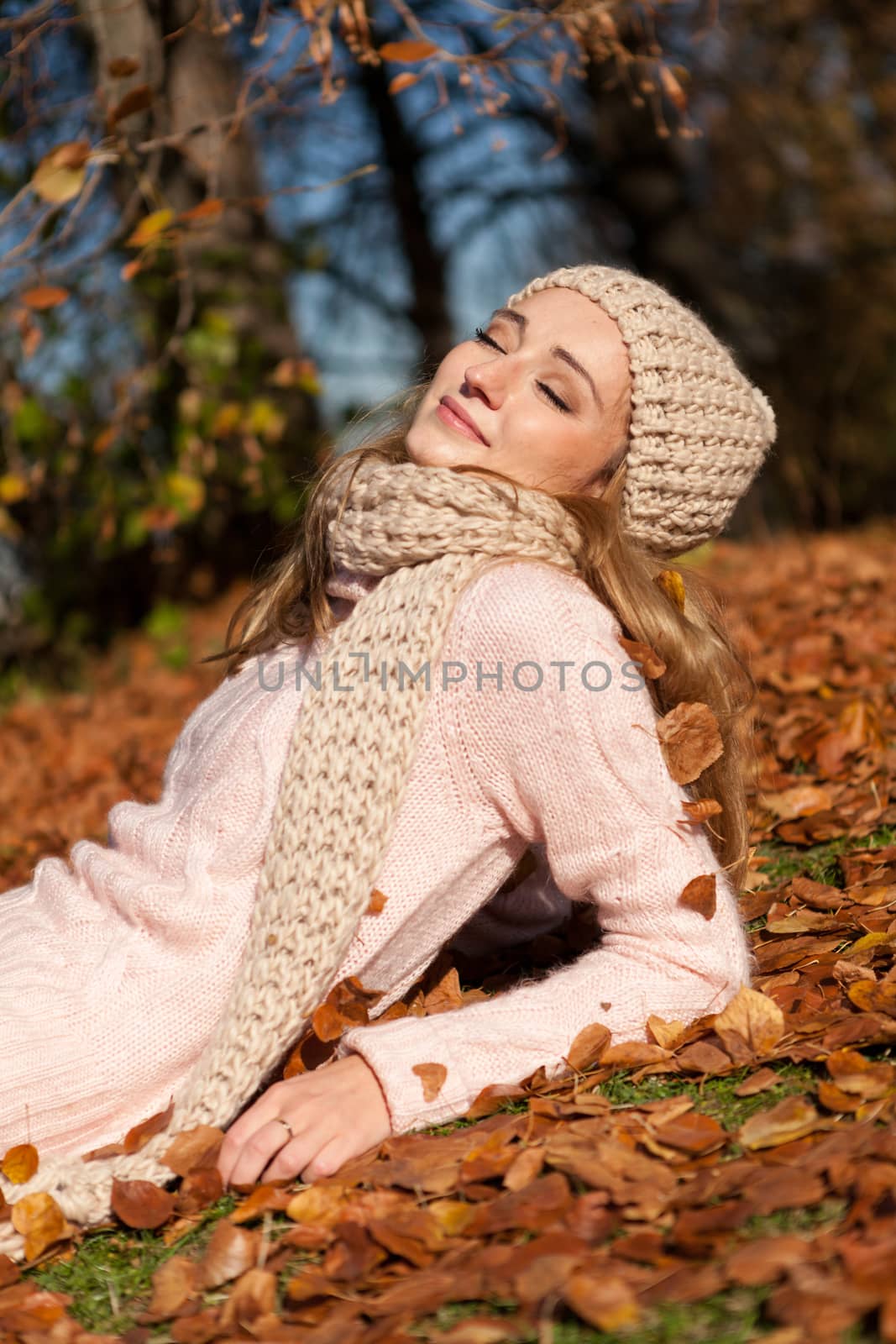 young smiling woman with hat and scarf outdoor in autumn by juniart