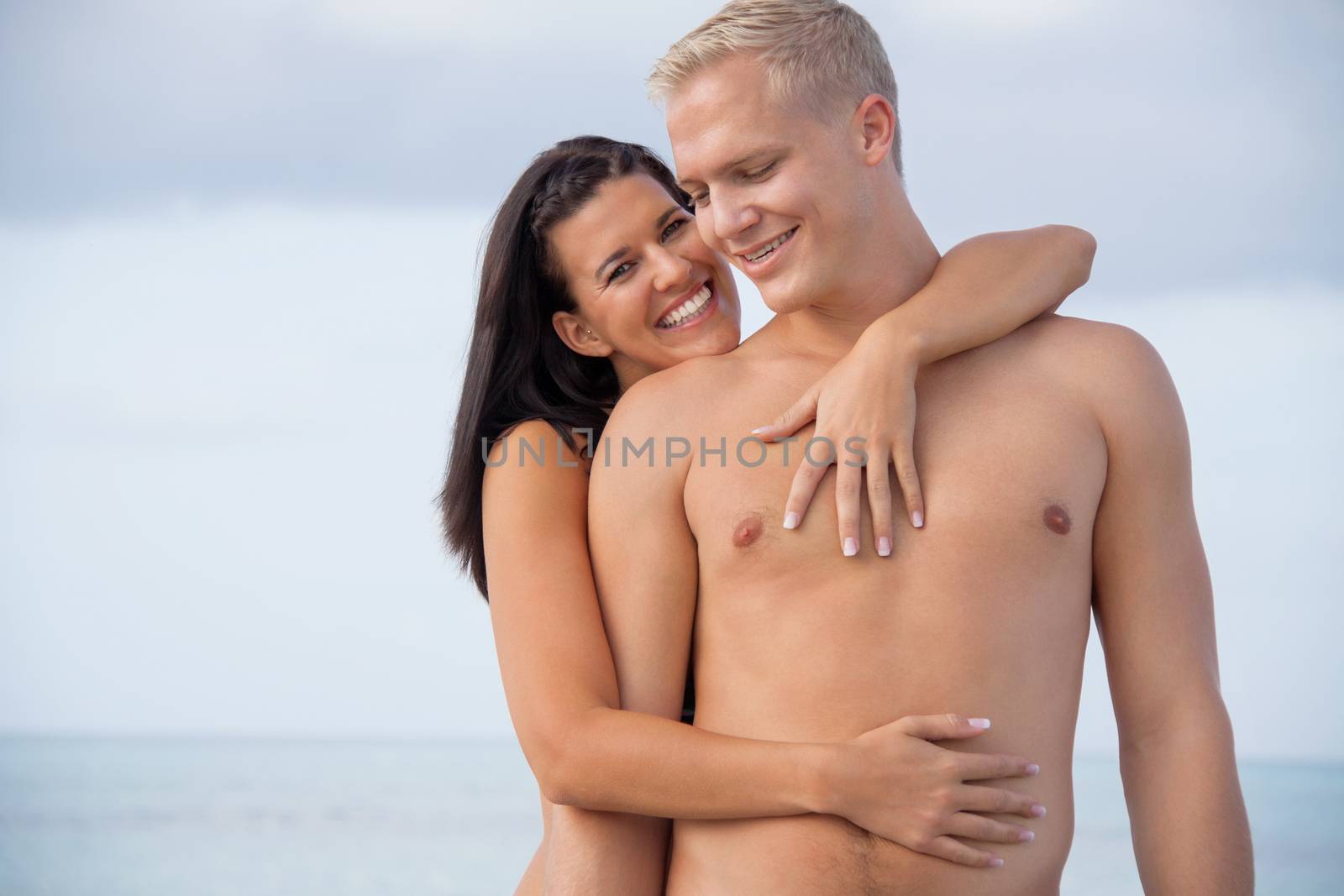 smiling young couple having fun in summer on the beach