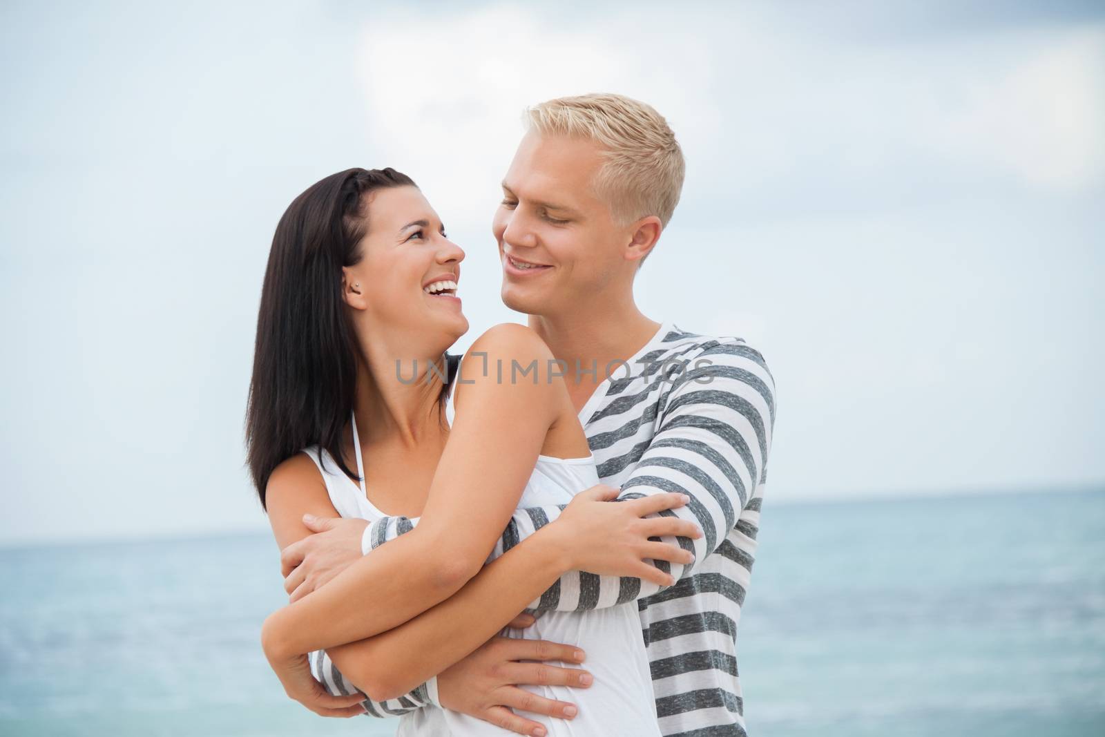 smiling young couple having fun in summer on the beach