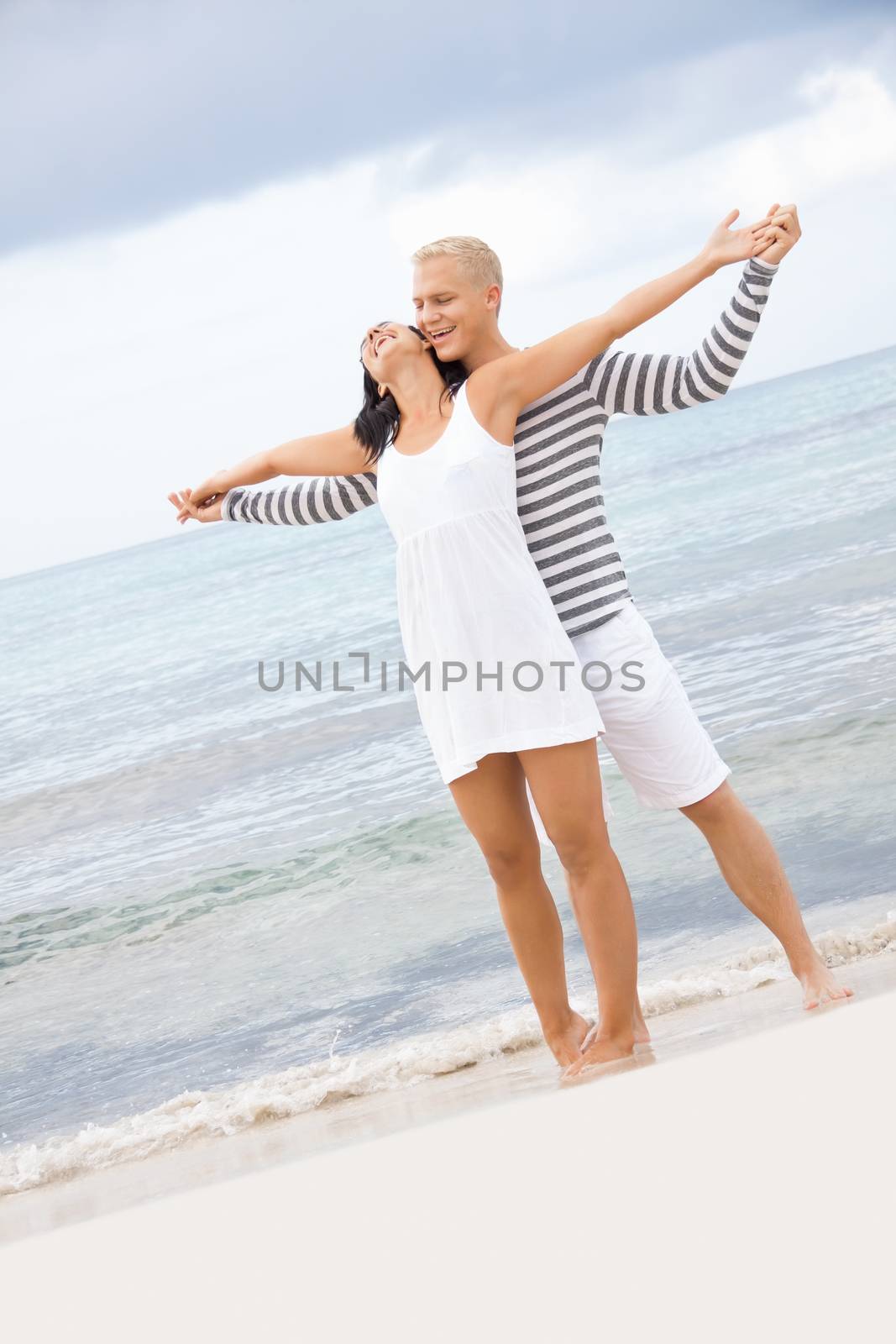 smiling young couple having fun in summer on the beach