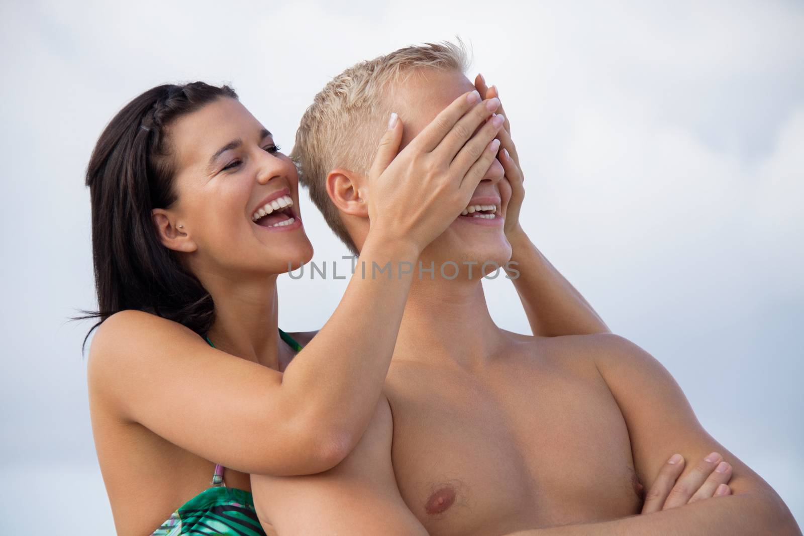 smiling young couple having fun in summer on the beach