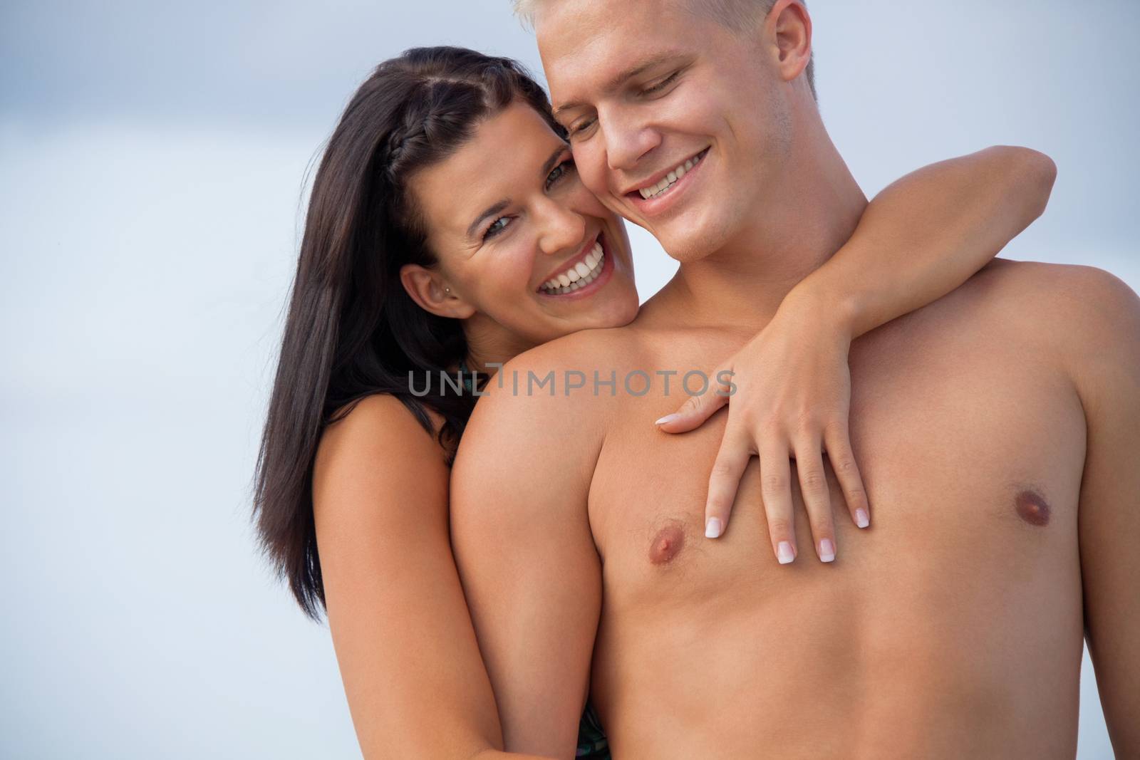 smiling young couple having fun in summer on the beach