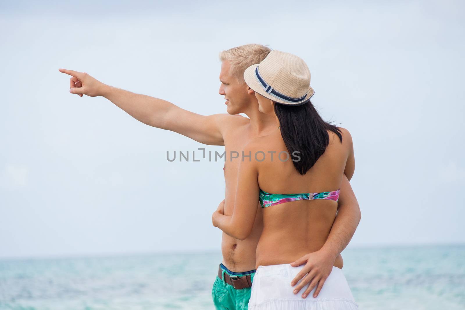 smiling young couple having fun in summer on the beach