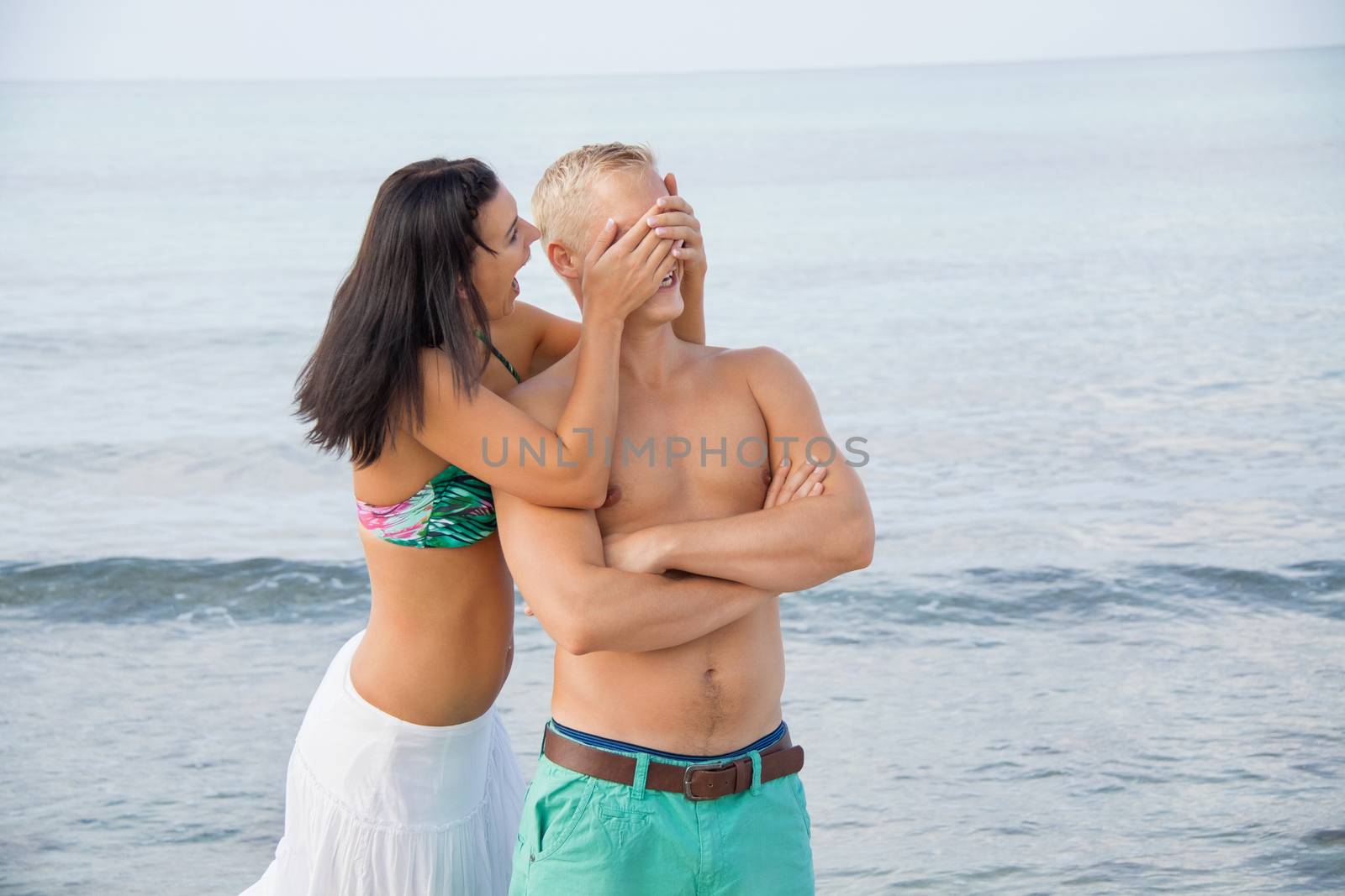 smiling young couple having fun in summer on the beach