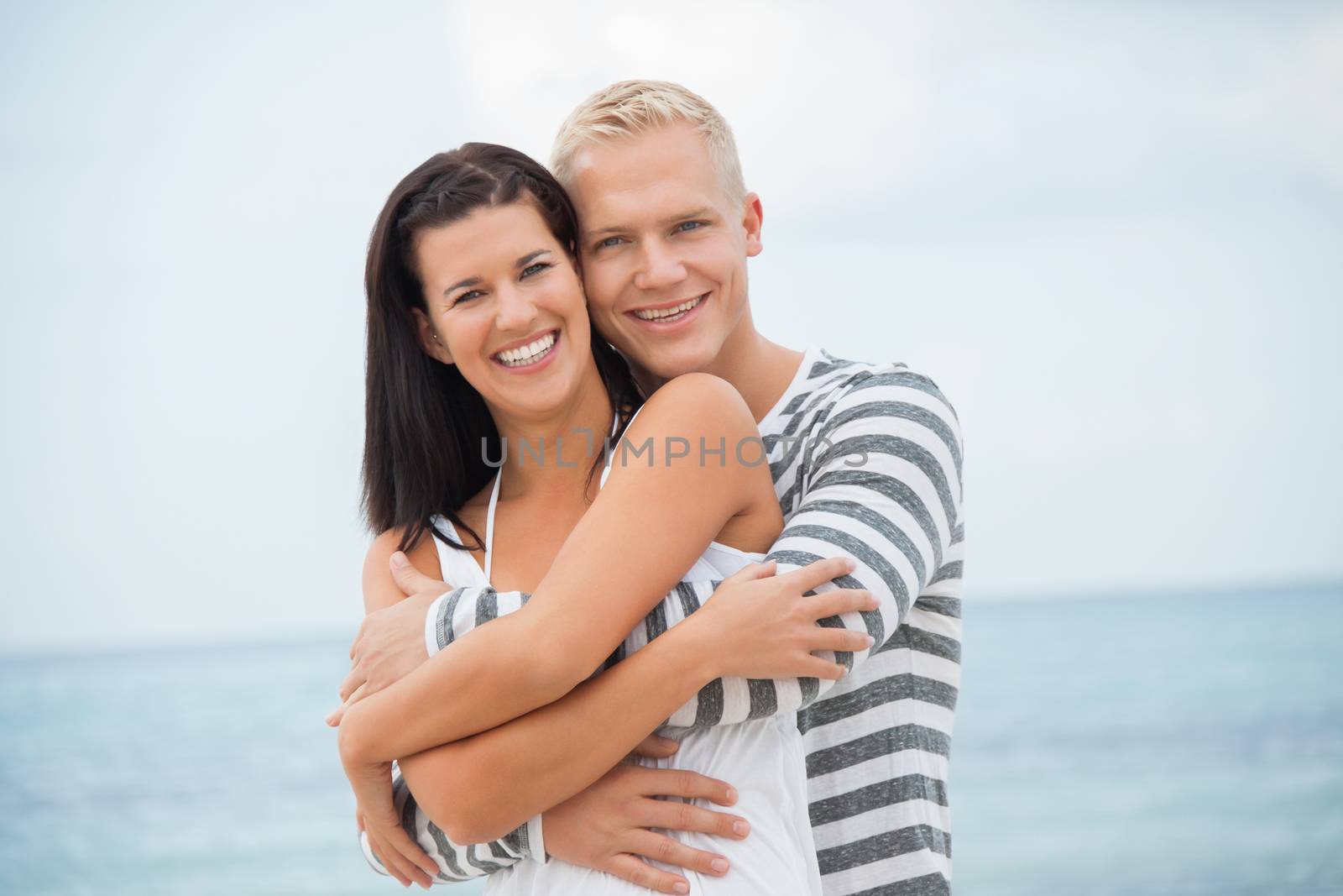 smiling young couple having fun in summer on the beach