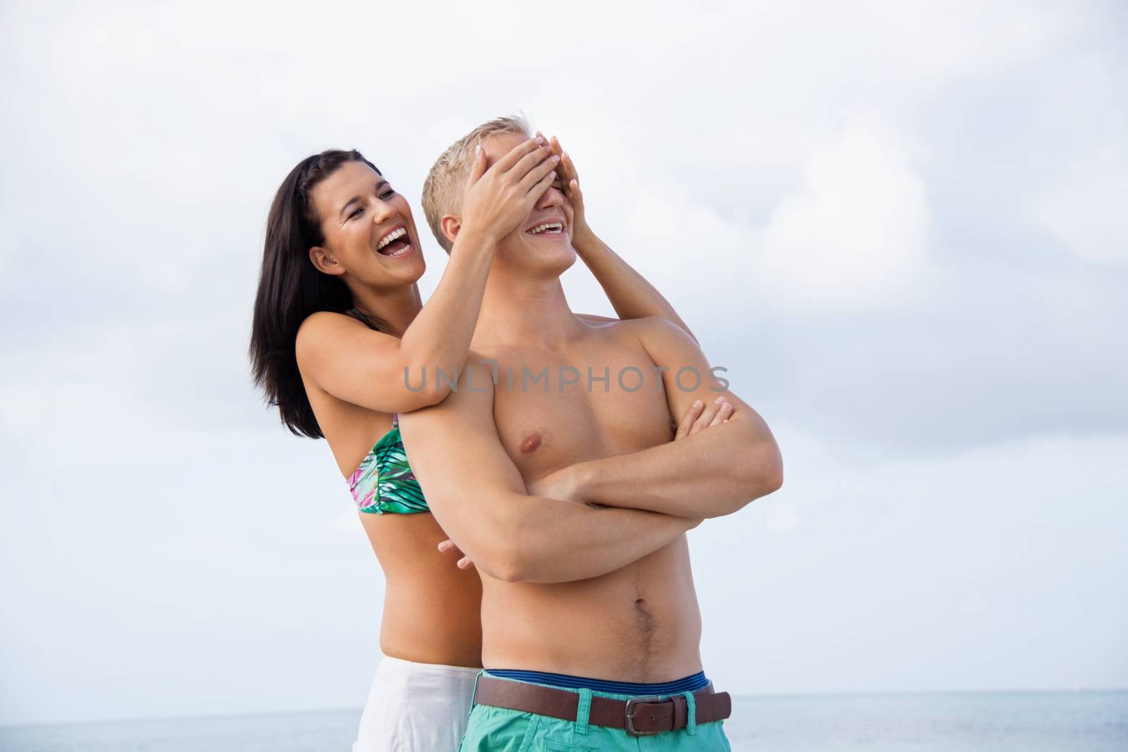 smiling young couple having fun in summer on the beach