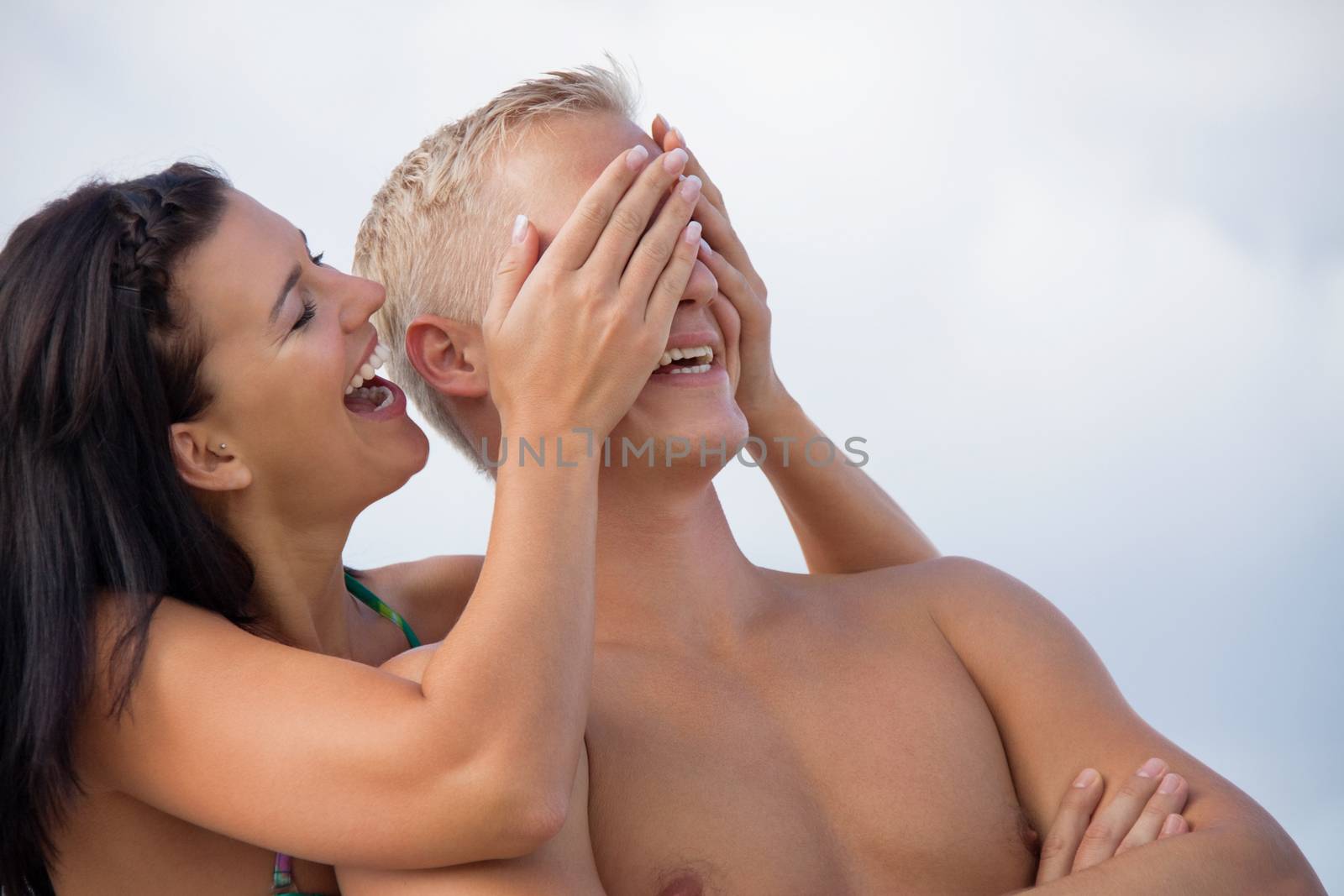 smiling young couple having fun in summer on the beach