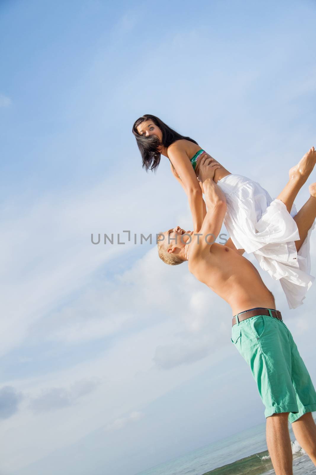 smiling young couple having fun in summer on the beach