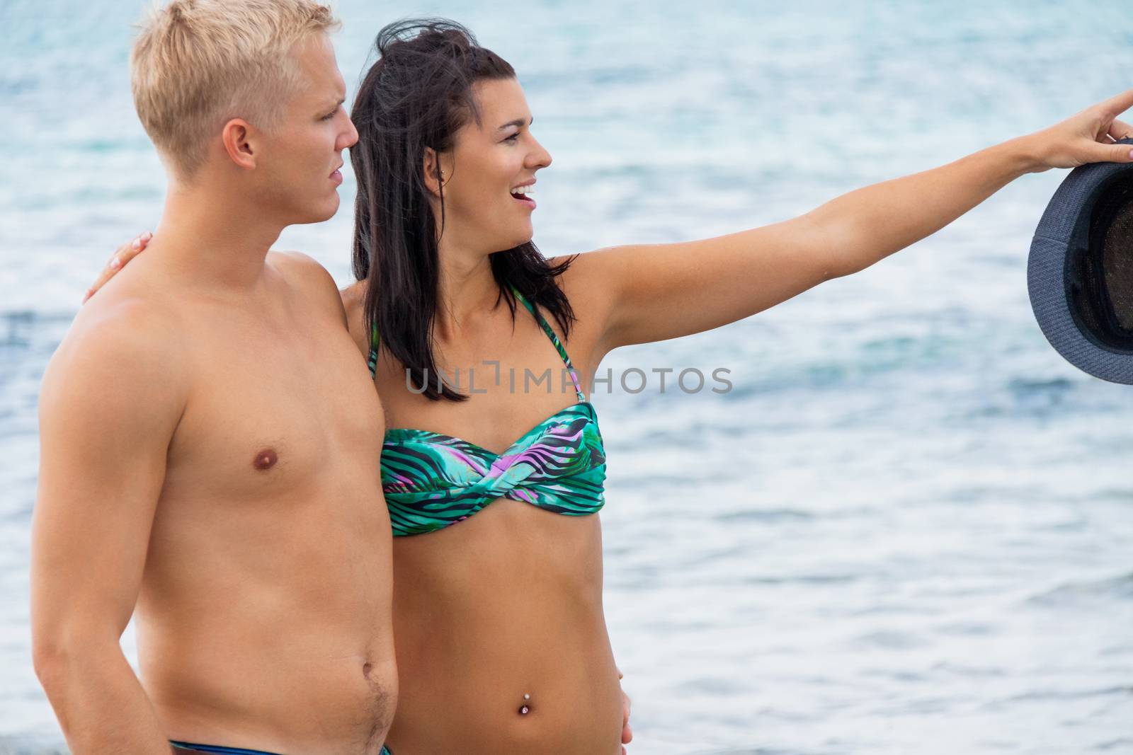 smiling young couple having fun in summer on the beach