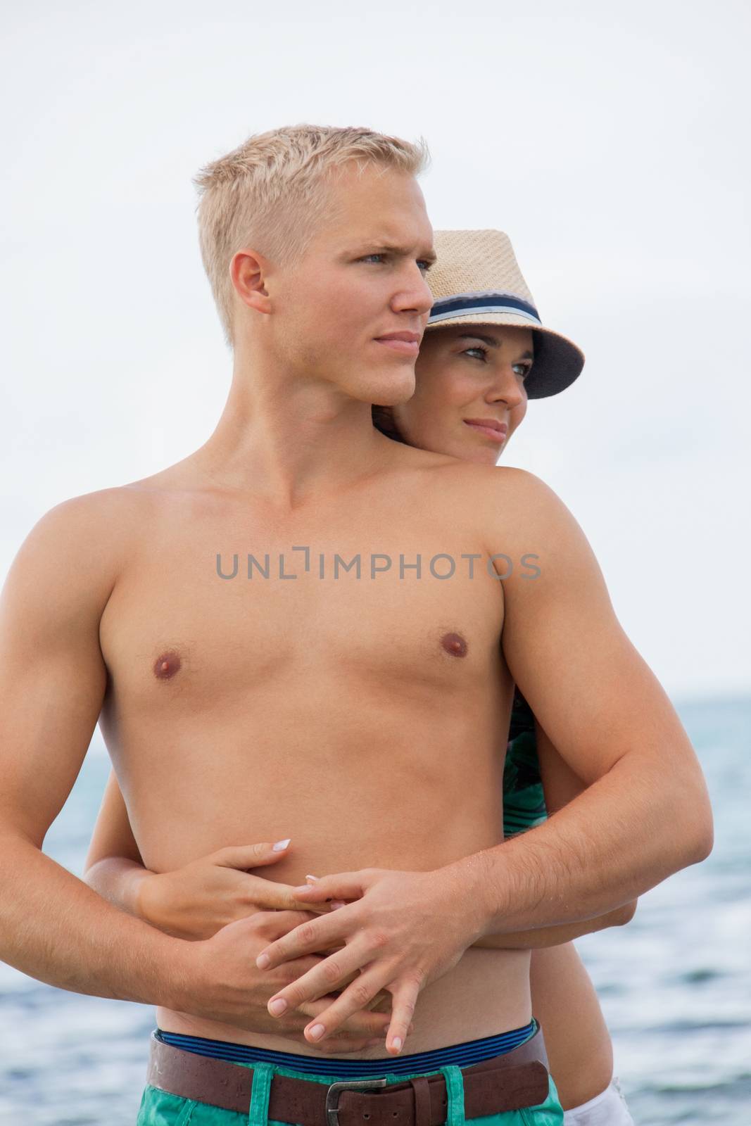 smiling young couple having fun in summer on the beach