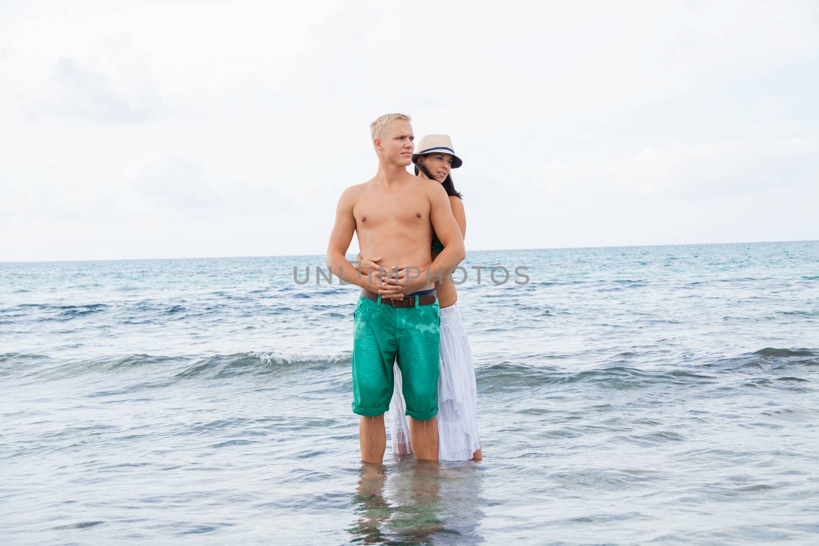 smiling young couple having fun in summer on the beach