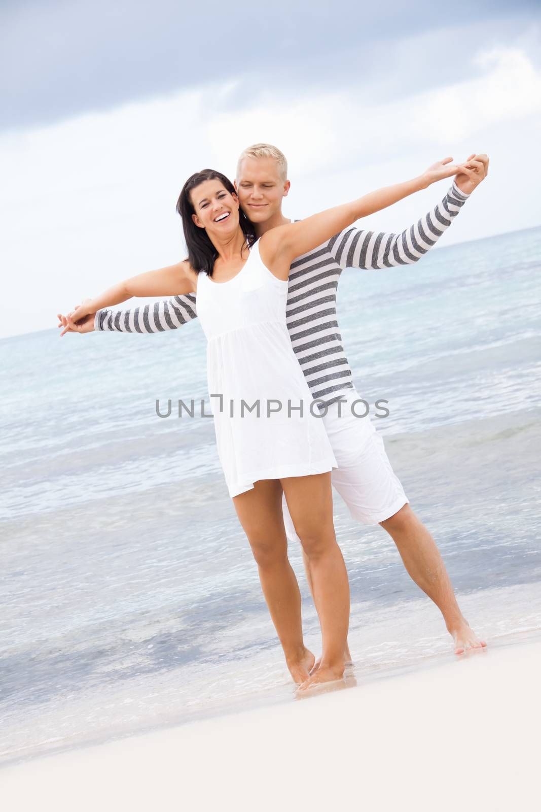 smiling young couple having fun in summer on the beach