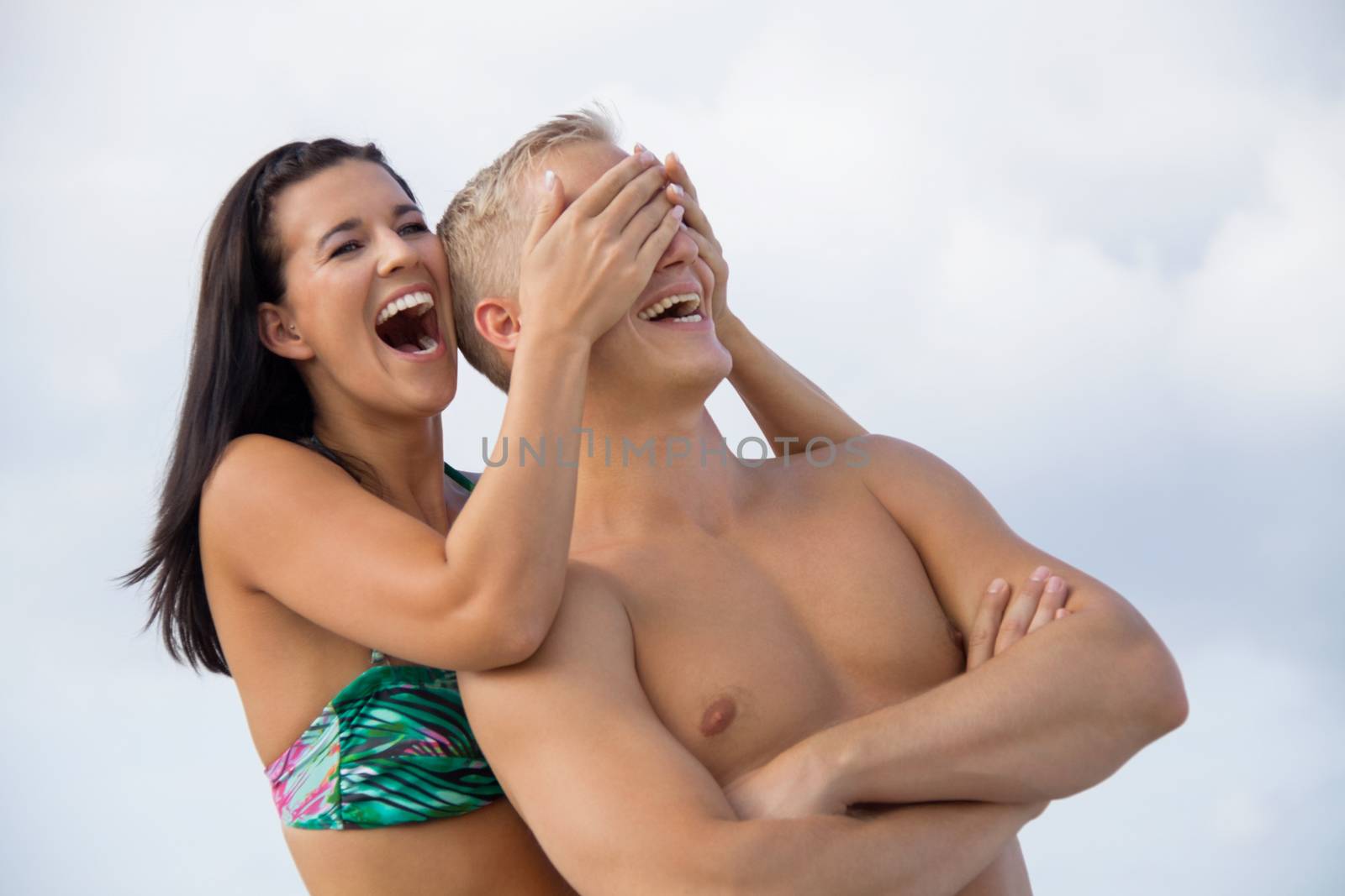 smiling young couple having fun in summer on the beach