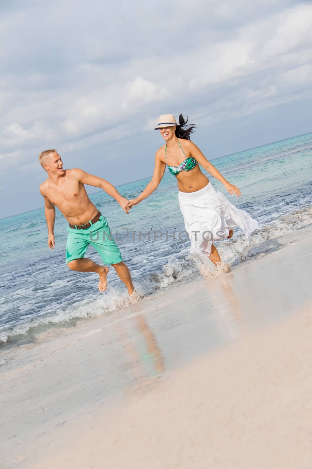 young happy couple walking on beach sunset holiday vacation