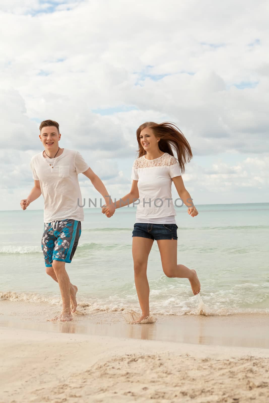 happy young couple on the beach in summer holiday love togetherness