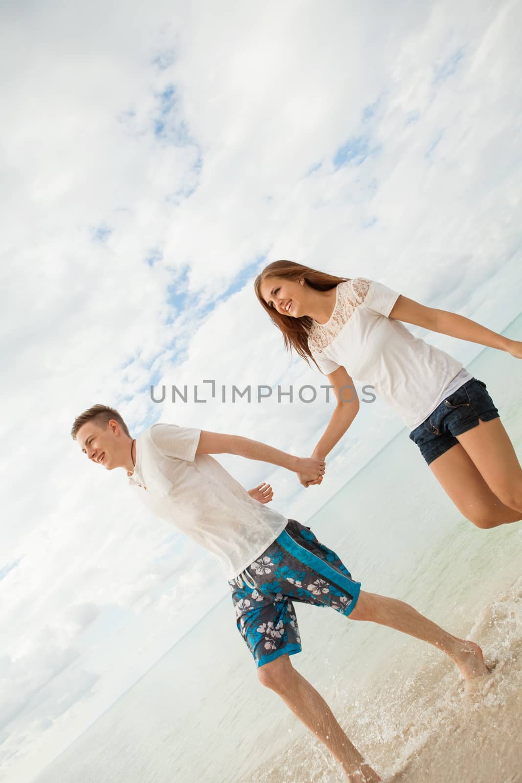 happy young couple on the beach in summer holiday love togetherness